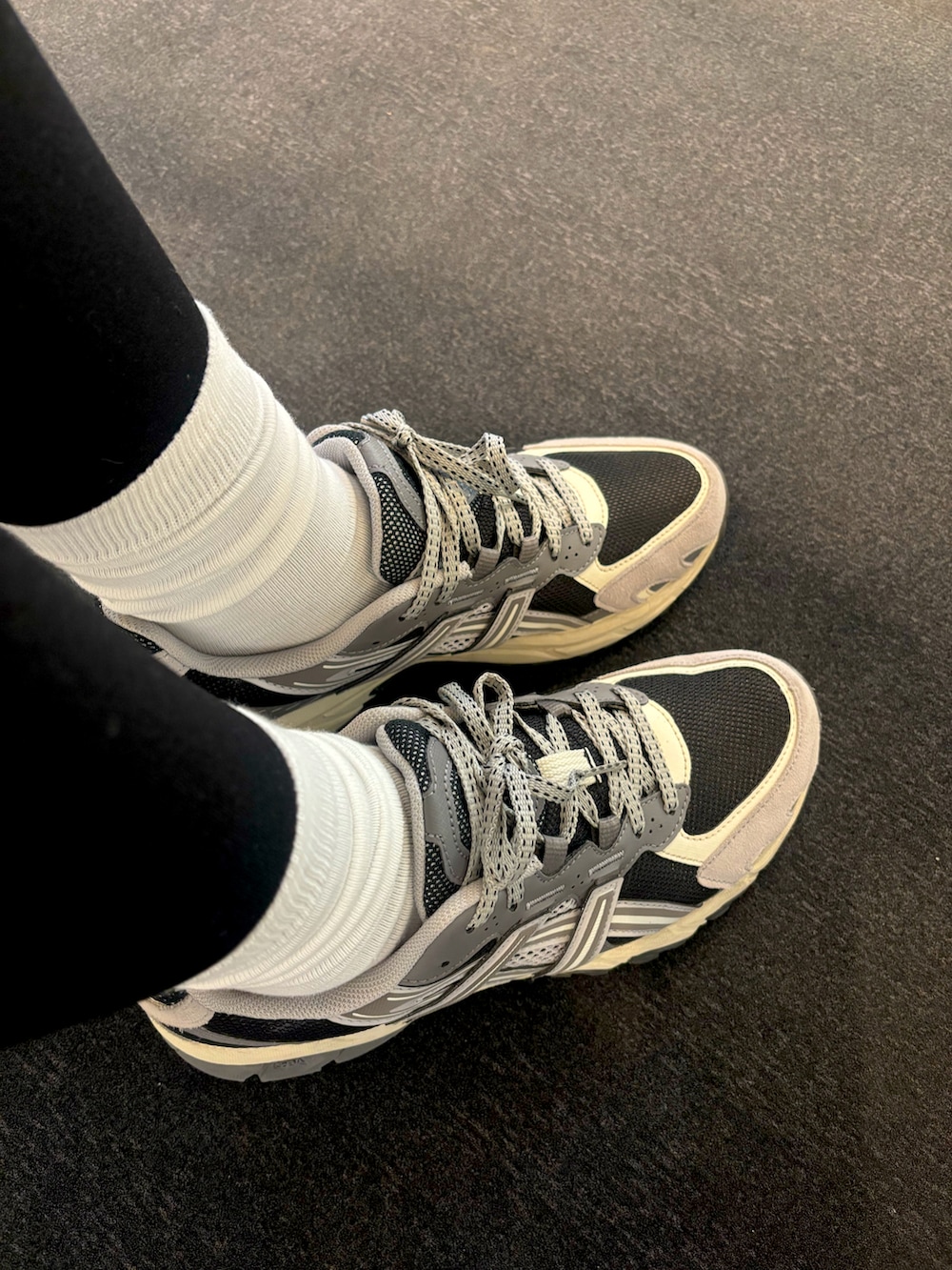 ブルー系のデニムパンツ、ブラック系のスニーカー、グレー系のニット/セーターを着用したレディースの冬コーディネートの2枚目の写真