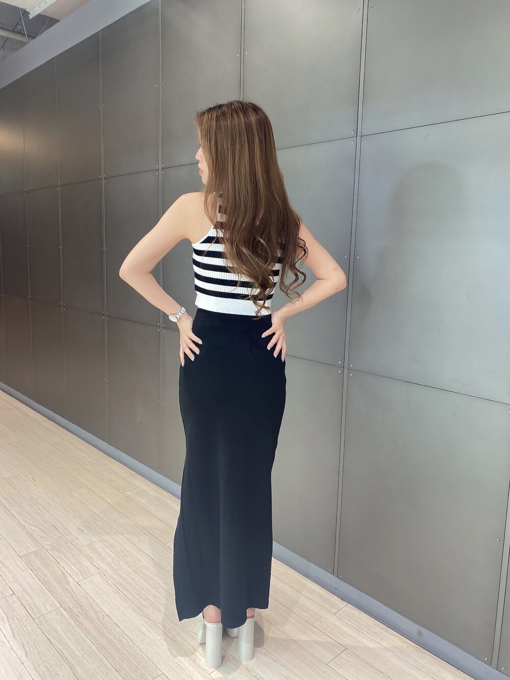 その他のタンクトップ、ブラック系のスカート、ホワイト系のサンダルを着用したレディースの夏コーディネートの3枚目の写真