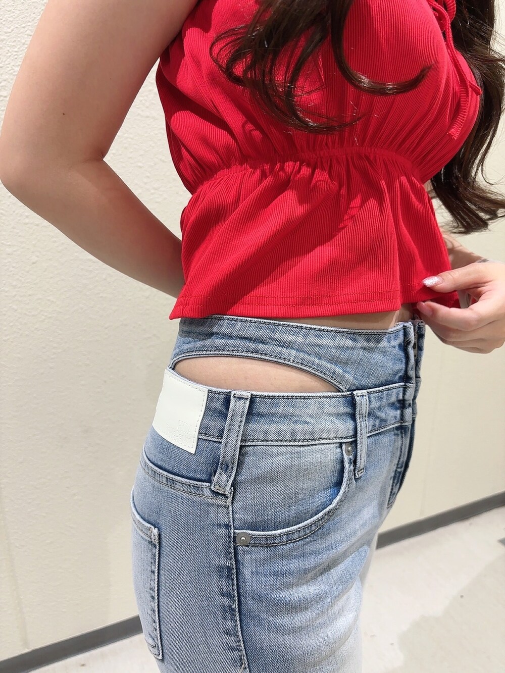 レッド系のTシャツ/カットソー、ブルー系のデニムパンツ、ホワイト系のサンダルを着用したレディースの春コーディネートの9枚目の写真