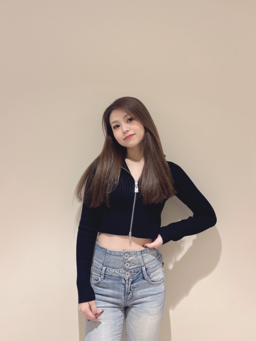 ブラック系のニット/セーター、ブルー系のデニムパンツ、ブラック系のブーツを着用したレディースの秋コーディネートの4枚目の写真