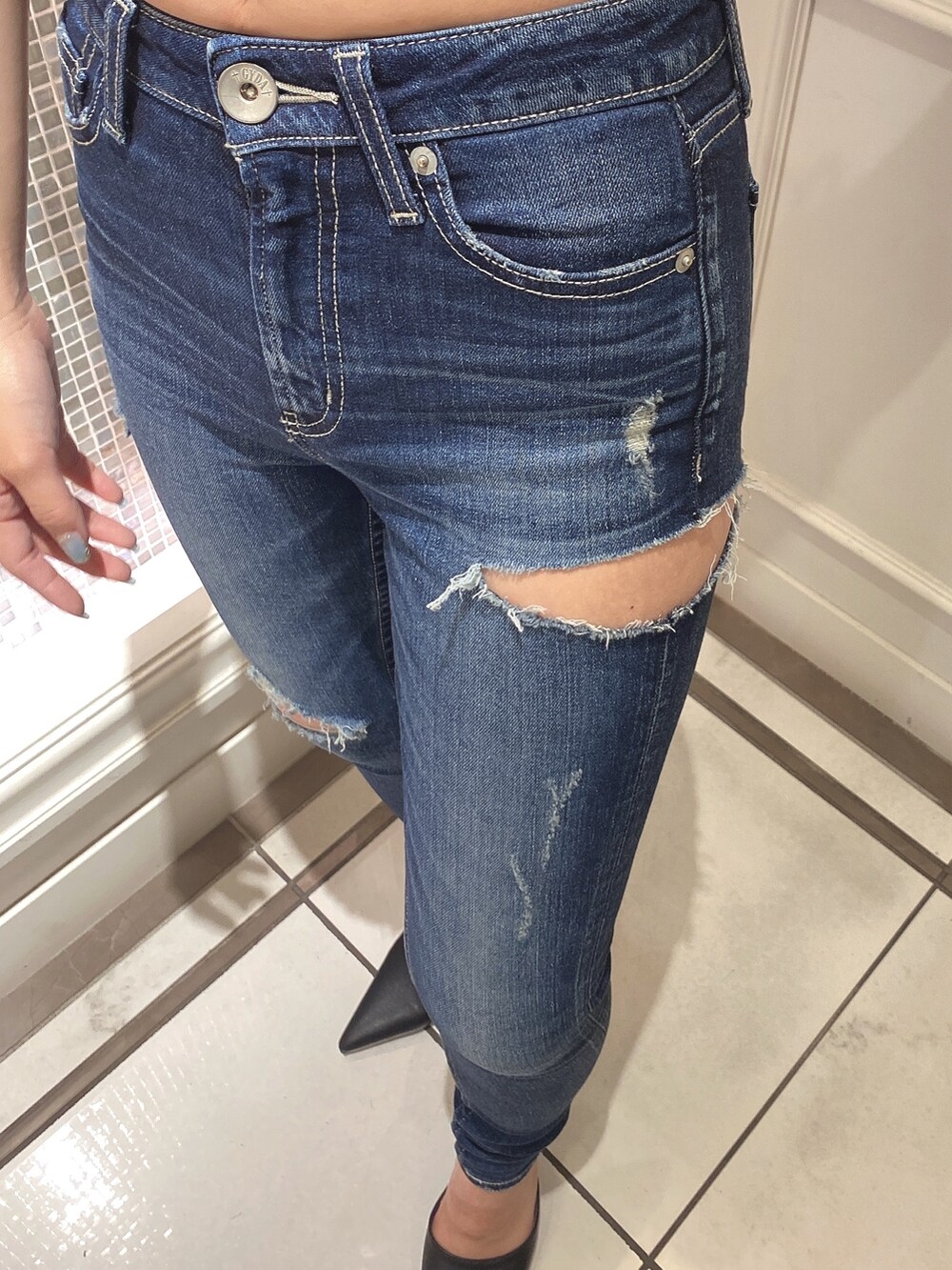 ブラック系のニット/セーター、ブルー系のデニムパンツ、ブラック系のパンプスを着用したレディースの夏コーディネートの6枚目の写真