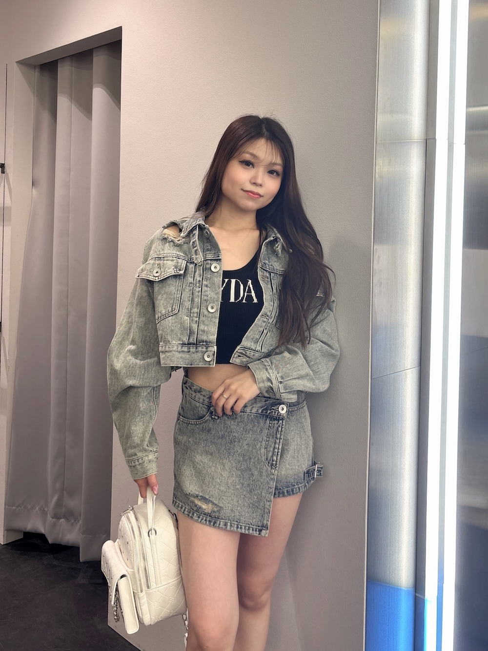 ブルー系のデニムジャケット、ブルー系のデニムパンツ、ホワイト系のバックパック/リュックを着用したレディースの夏コーディネートの4枚目の写真