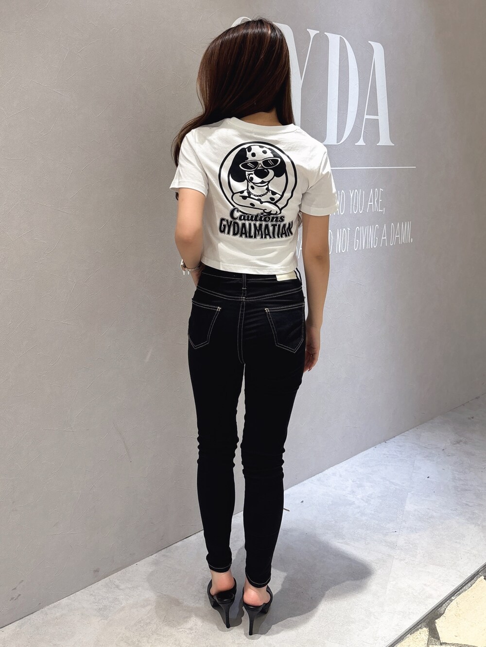 ホワイト系のTシャツ/カットソー、ブラック系のデニムパンツ、ホワイト系のパンプスを着用したレディースの夏コーディネートの3枚目の写真