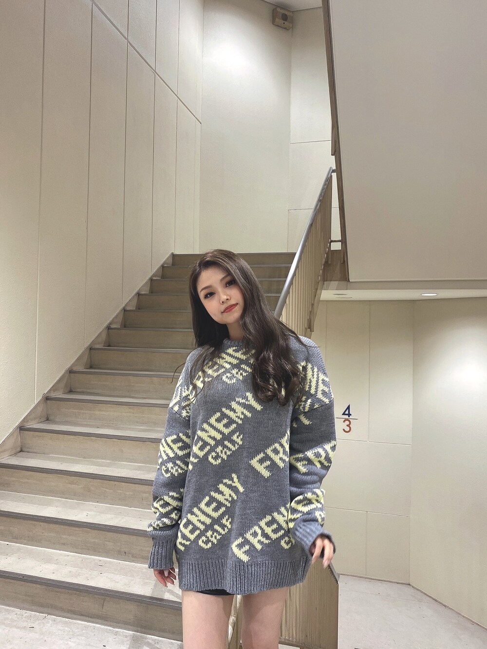 グレー系のニット/セーター、ブラック系のブーツを着用したレディースの秋コーディネートの4枚目の写真