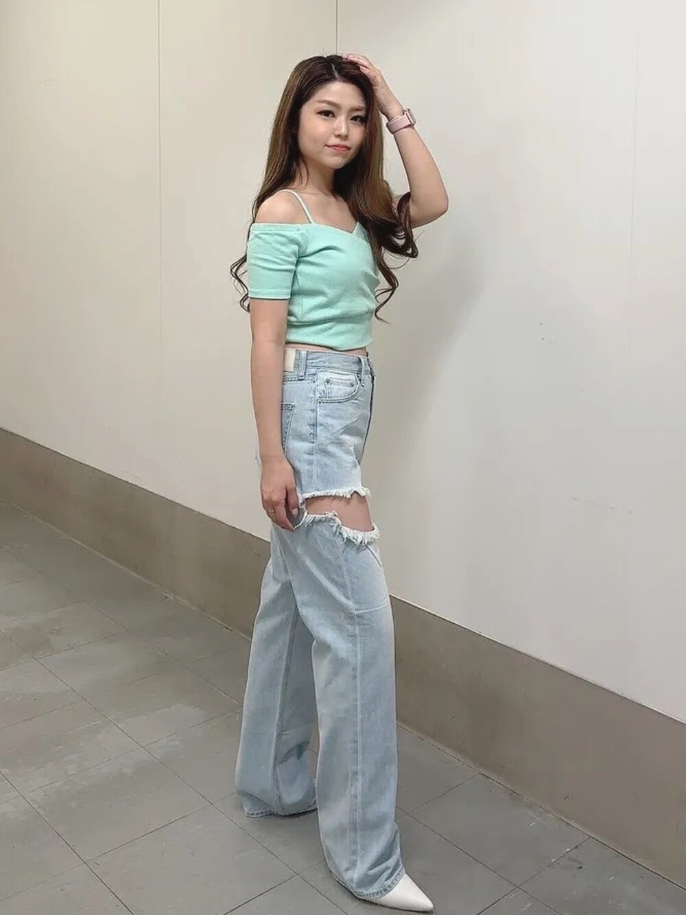 グリーン系のTシャツ/カットソー、ブルー系のデニムパンツ、ホワイト系のパンプスを着用したレディースの春コーディネートの3枚目の写真