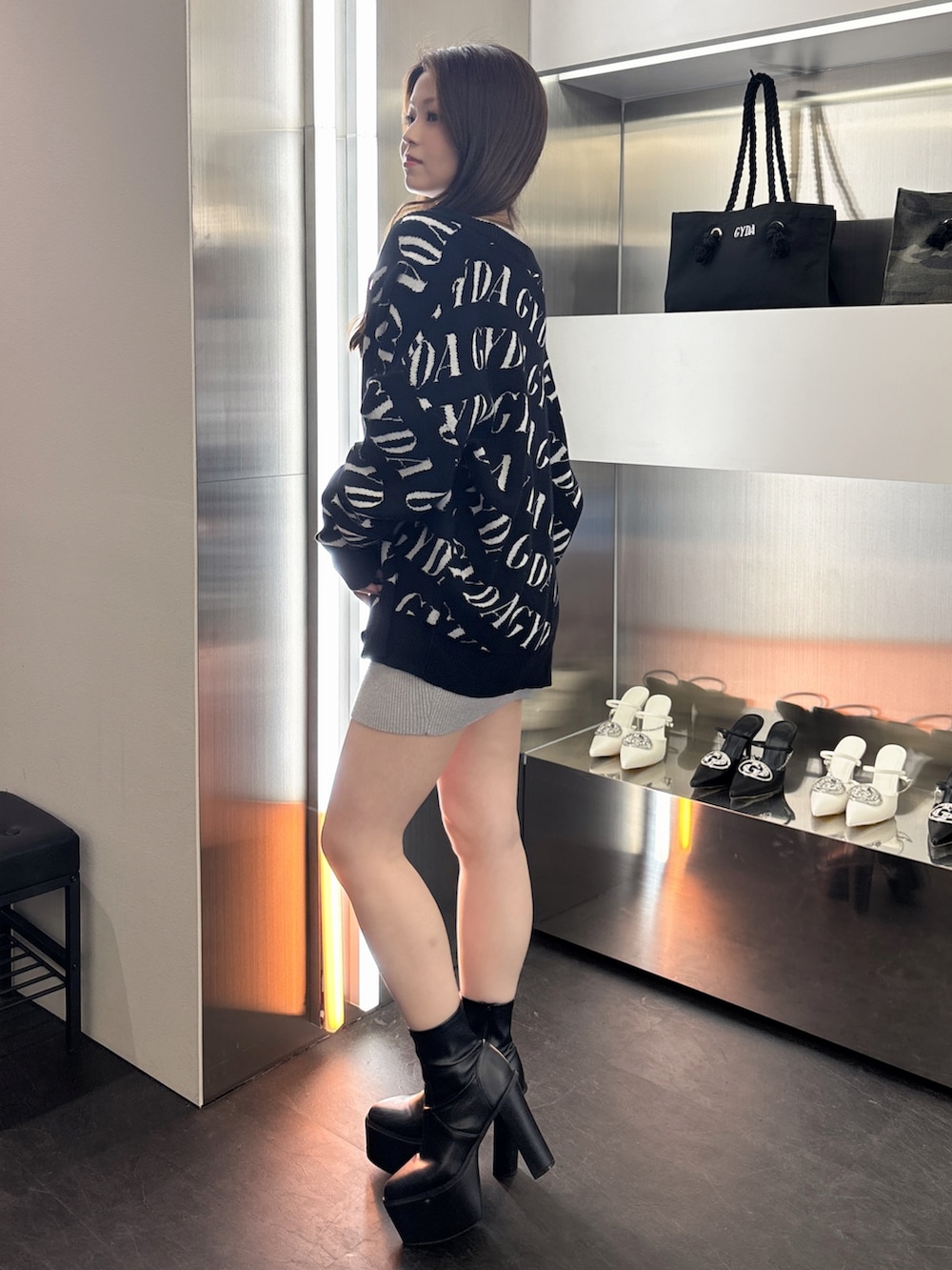 ブラック系のカーディガン/ボレロ、シルバー系のワンピース、ブラック系のブーツを着用したレディースの春コーディネートの2枚目の写真