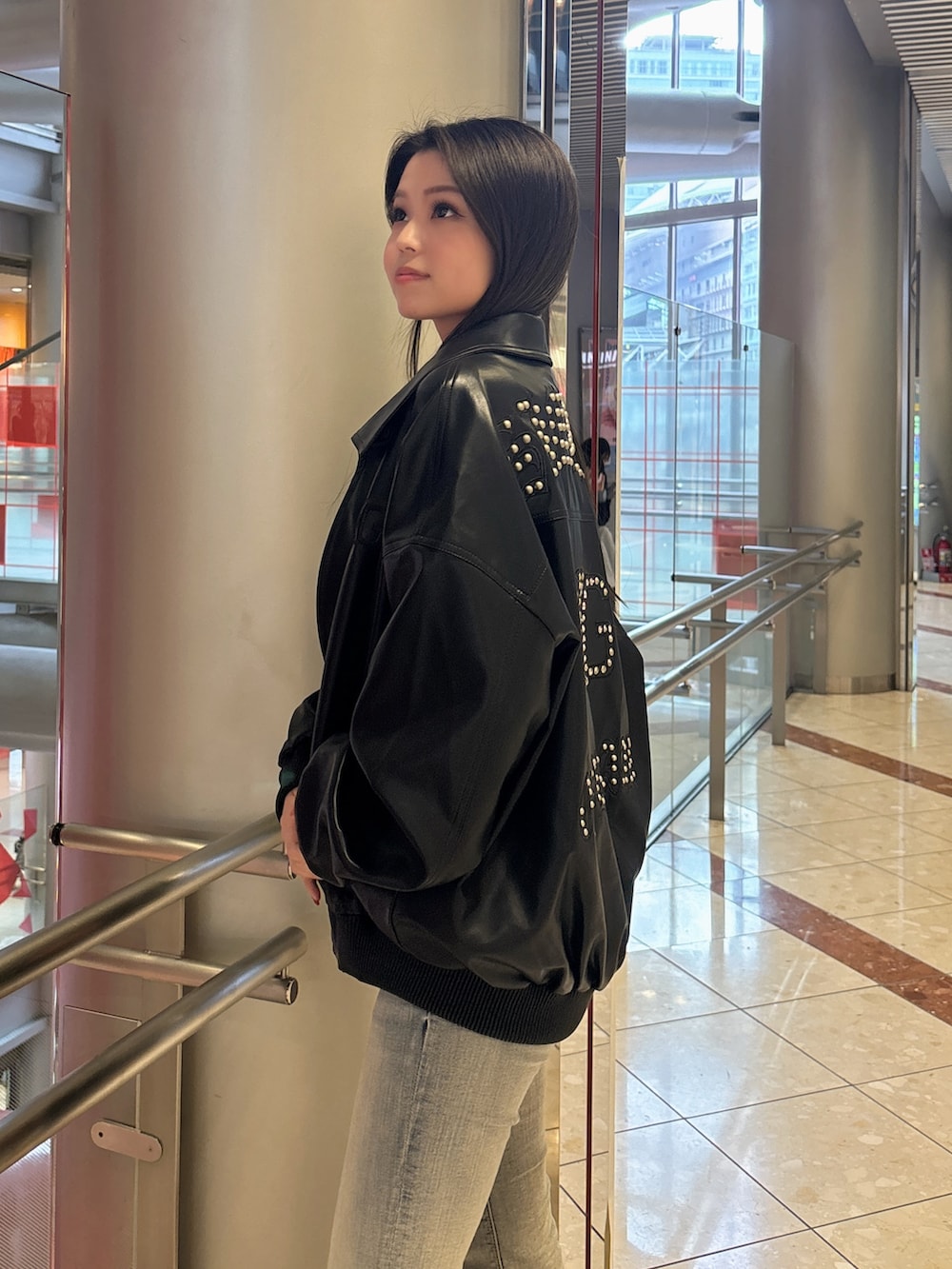 ブラック系のブルゾン、ブルー系のデニムパンツ、ブラック系のブーツを着用したレディースの春コーディネートの5枚目の写真