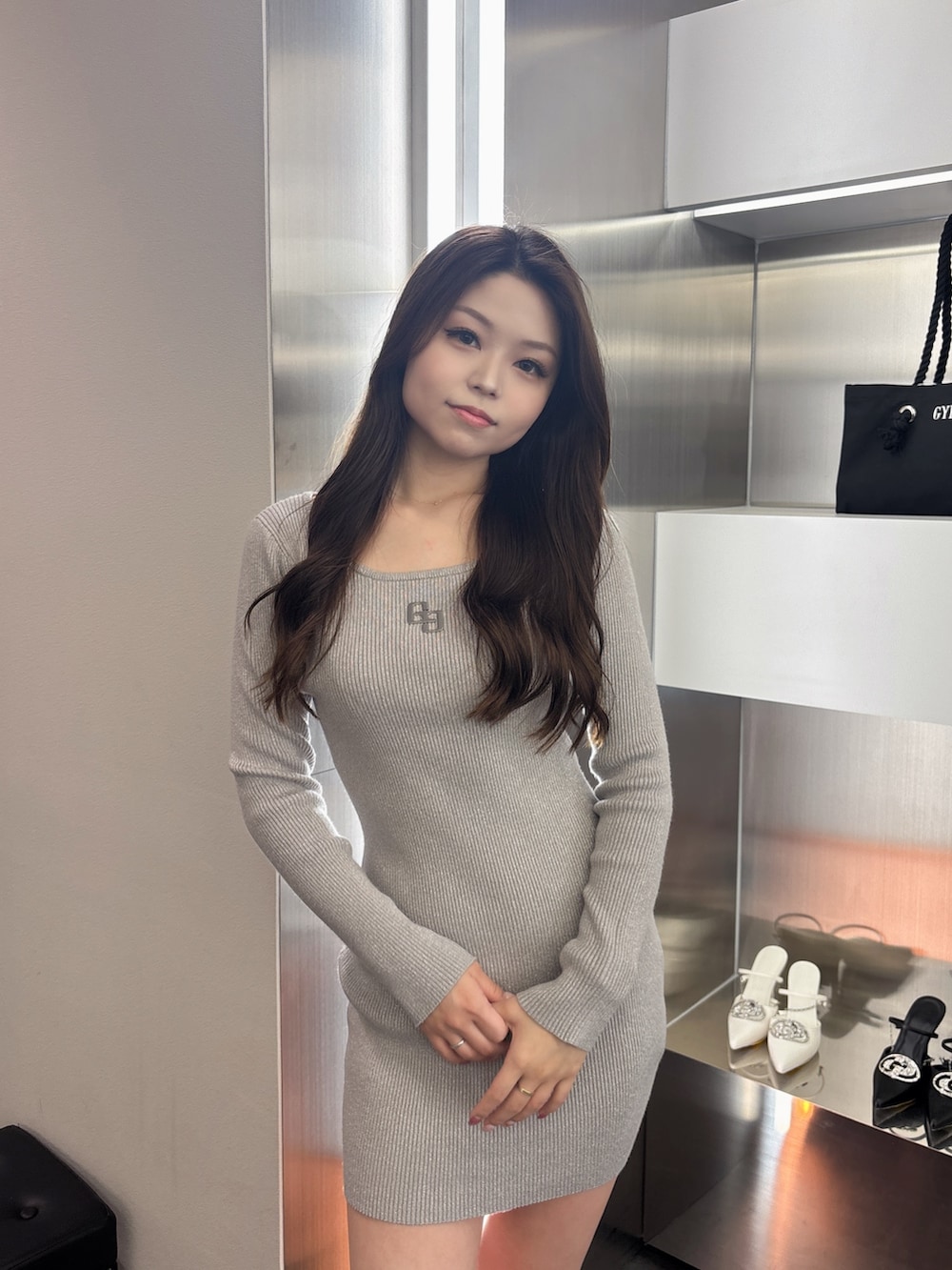 シルバー系のワンピース、ブラック系のブーツを着用したレディースの春コーディネートの4枚目の写真