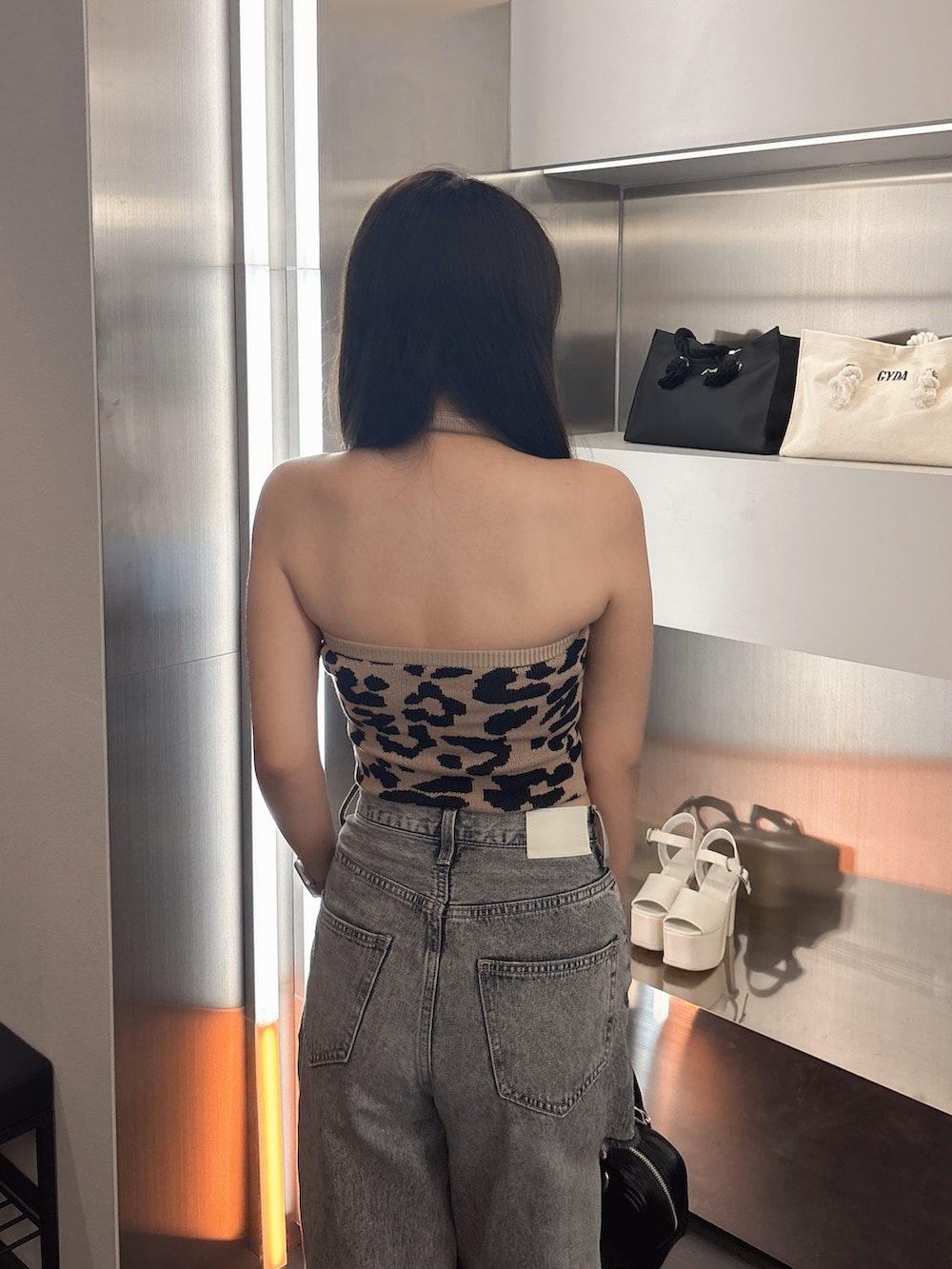 その他のキャミソール、ブルー系のデニムパンツ、ホワイト系のサンダルを着用したレディースの春コーディネートの6枚目の写真