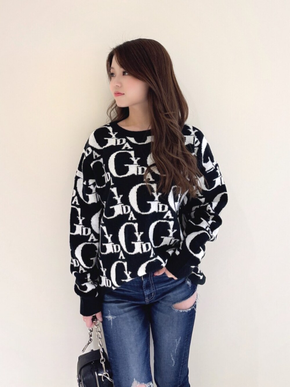 ホワイト系のパンプス、ブラック系のニット/セーター、ブルー系のデニムパンツを着用したレディースの冬コーディネートの6枚目の写真