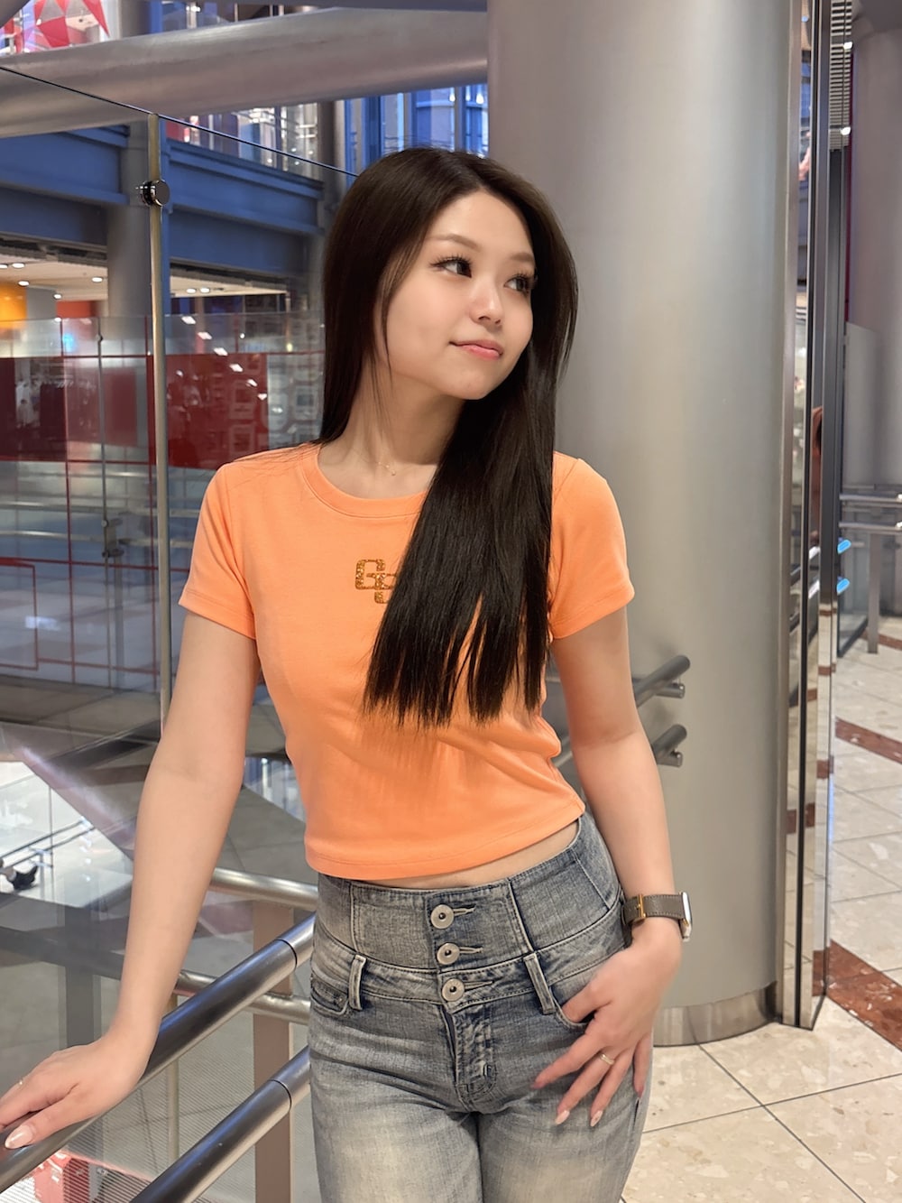 オレンジ系のTシャツ/カットソー、ブルー系のデニムパンツ、ブラック系のサンダルを着用したレディースの春コーディネートの4枚目の写真