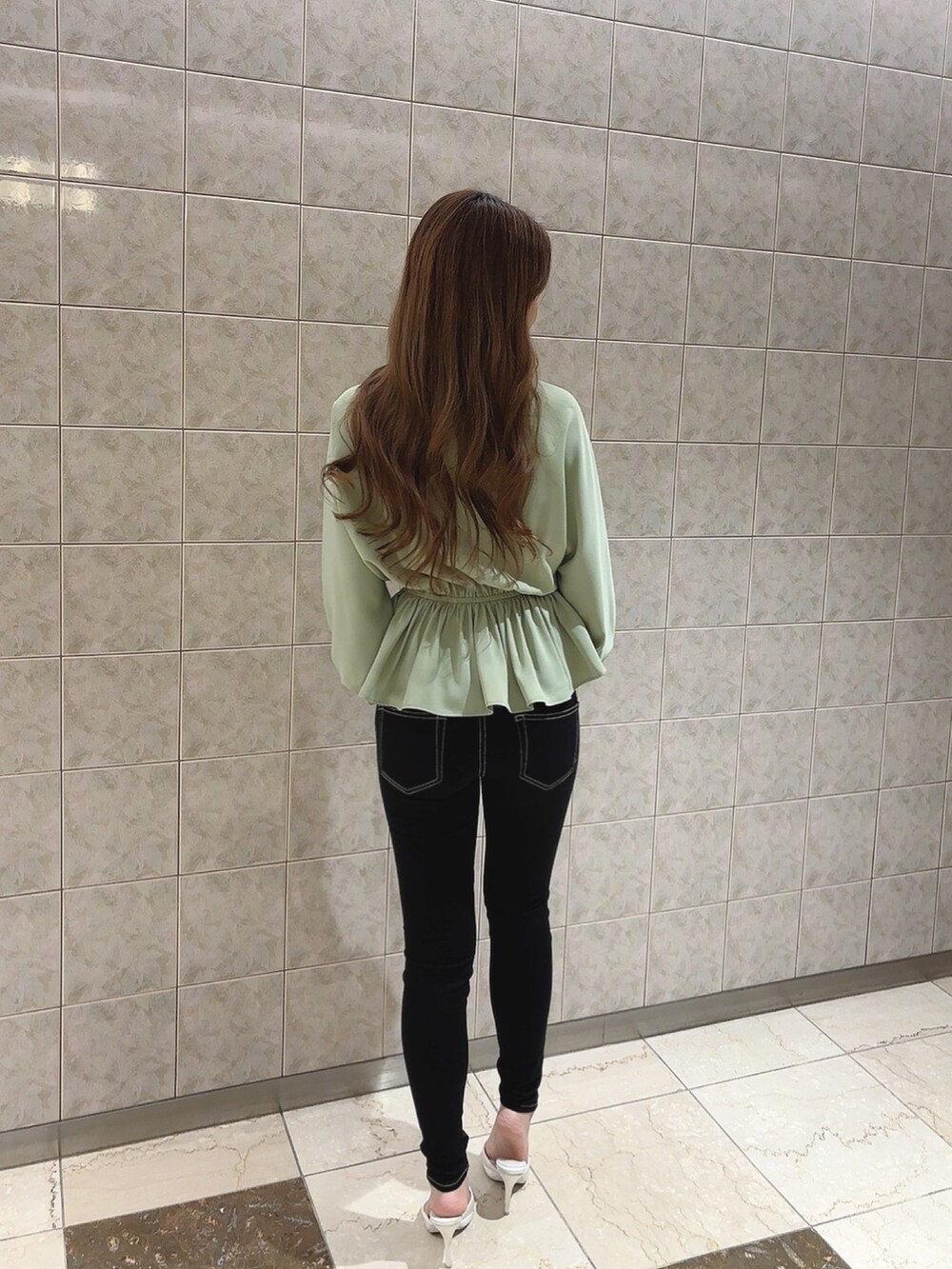 グリーン系のシャツ/ブラウス、ブラック系のデニムパンツ、ホワイト系のパンプスを着用したレディースの冬コーディネートの5枚目の写真