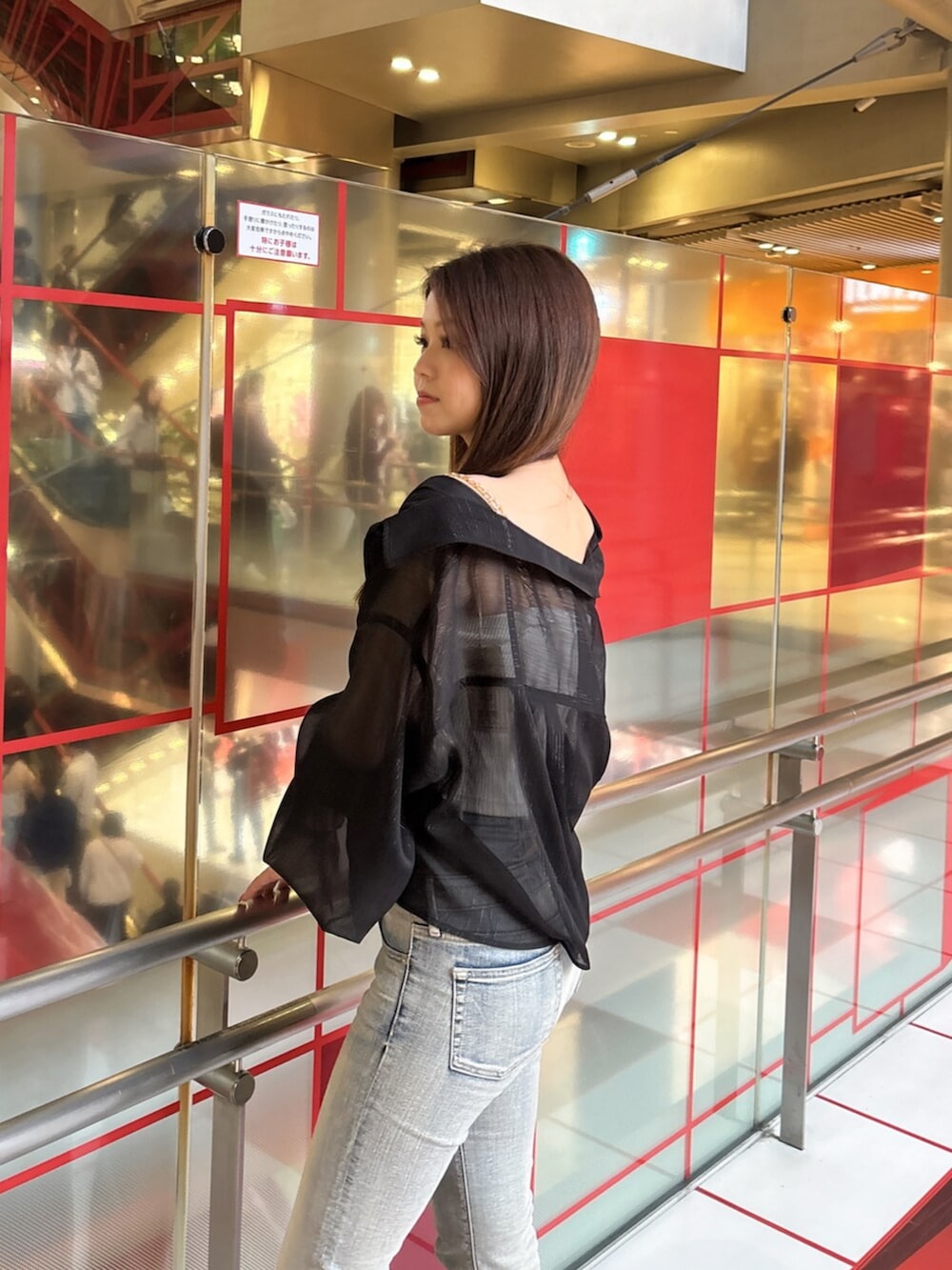 ブラック系のブーツ、ブルー系のデニムパンツ、ホワイト系のキャミソールを着用したレディースの春コーディネートの5枚目の写真