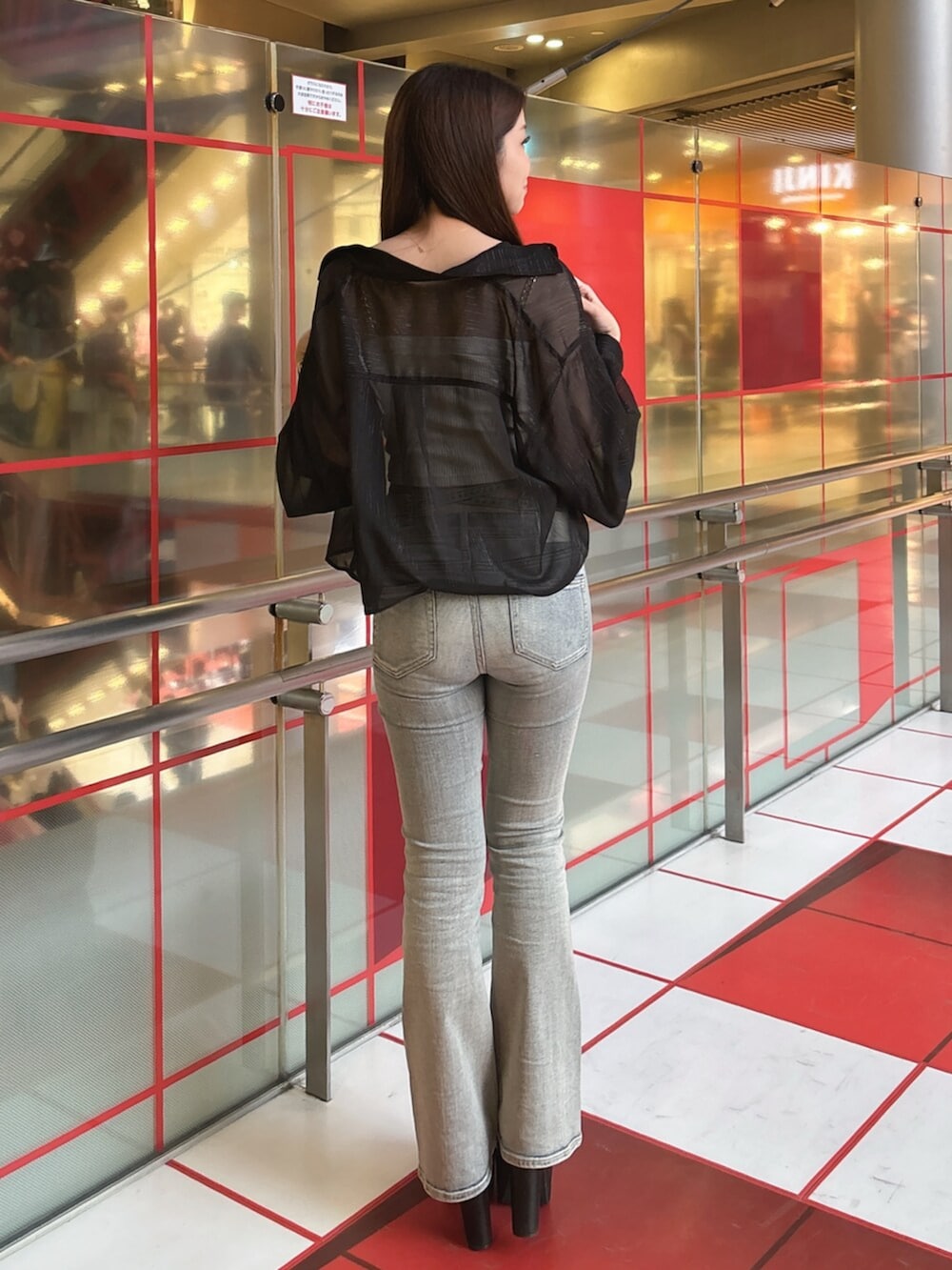 ブラック系のブーツ、ブルー系のデニムパンツ、ホワイト系のキャミソールを着用したレディースの春コーディネートの3枚目の写真