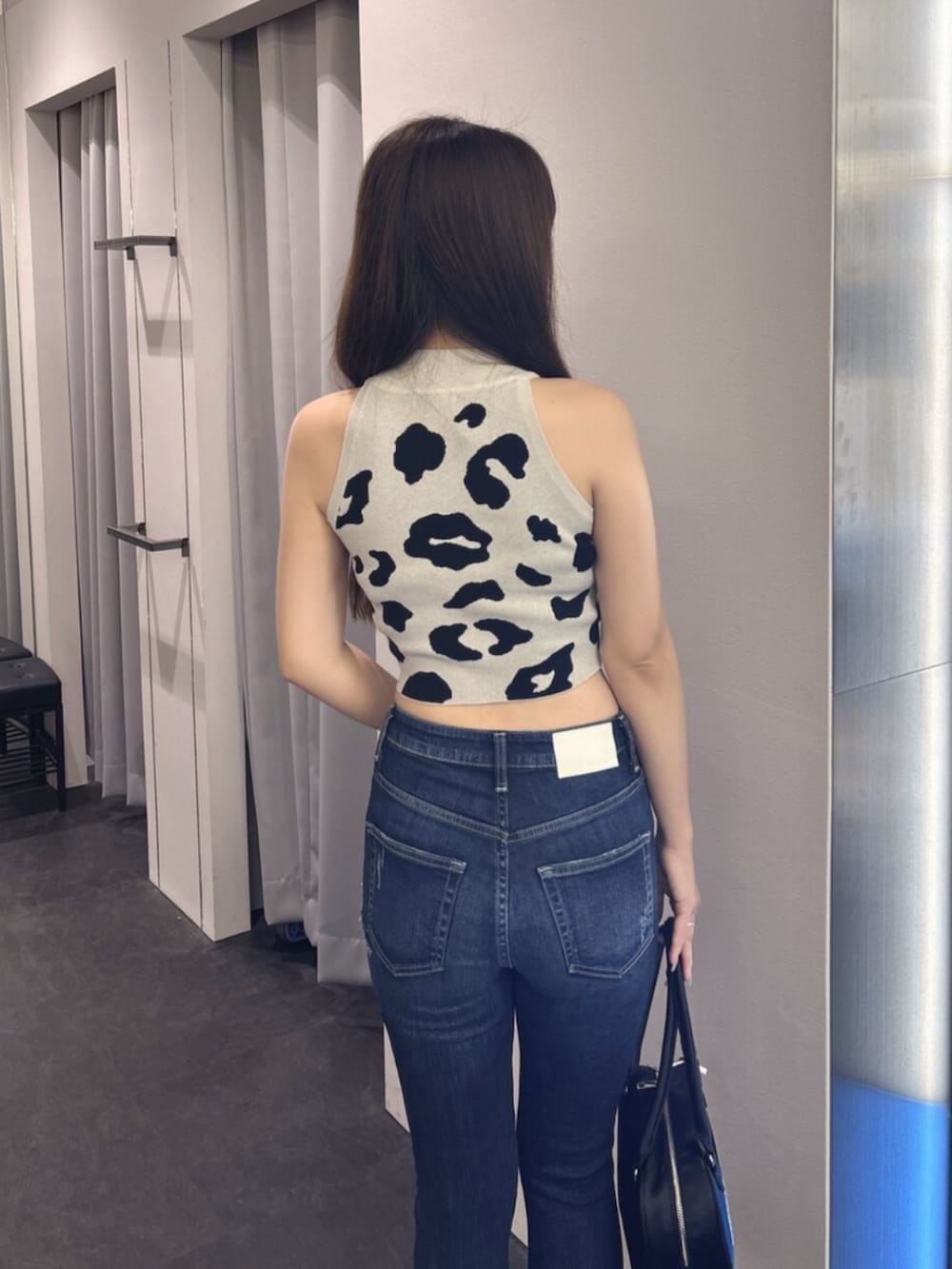 ブルー系のデニムパンツ、ホワイト系のサンダル、ピンク系のボストンバッグを着用したレディースの夏コーディネートの6枚目の写真