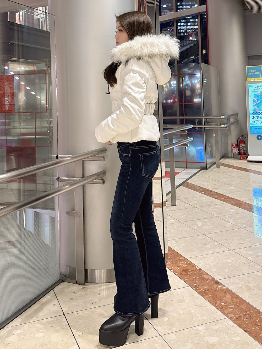 ブラック系のダウンジャケット/コート、ブルー系のデニムパンツ、ブラック系のブーツを着用したレディースの冬コーディネートの2枚目の写真