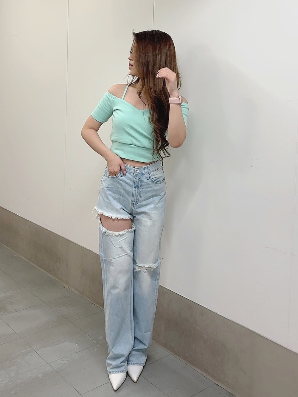 グリーン系のTシャツ/カットソー、ブルー系のデニムパンツ、ホワイト系のパンプスを着用したレディースの春コーディネートの2枚目の写真