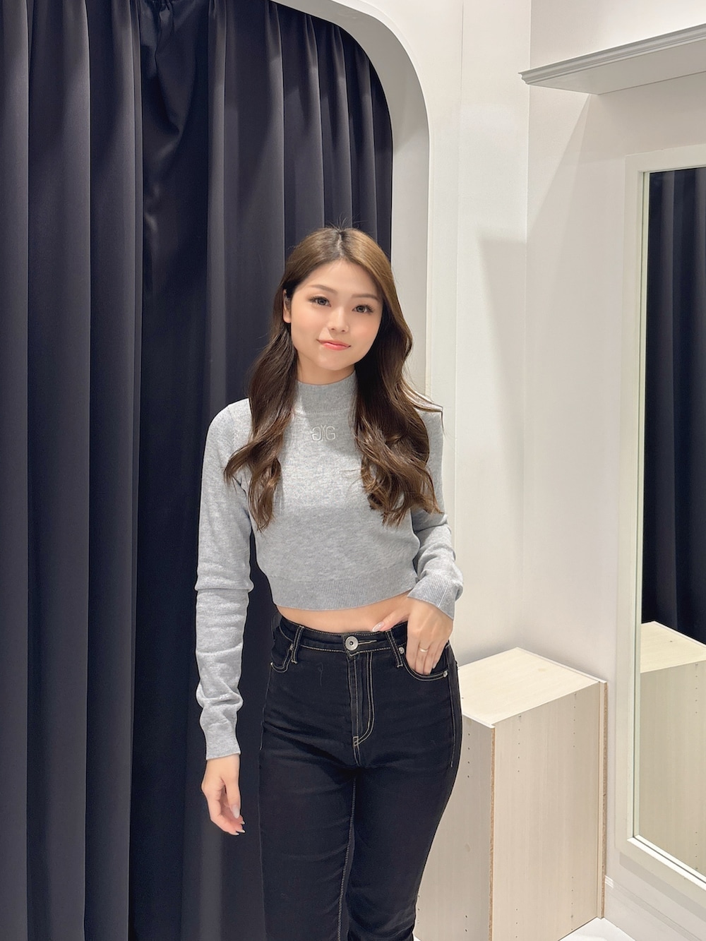 グレー系のニット/セーター、ブラック系のブーツ、ブラック系のデニムパンツを着用したレディースの冬コーディネートの4枚目の写真