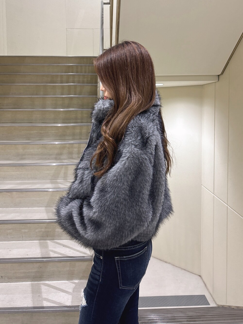 グレー系のその他アウター、ブルー系のデニムパンツ、ブラック系のパンプスを着用したレディースの冬コーディネートの7枚目の写真