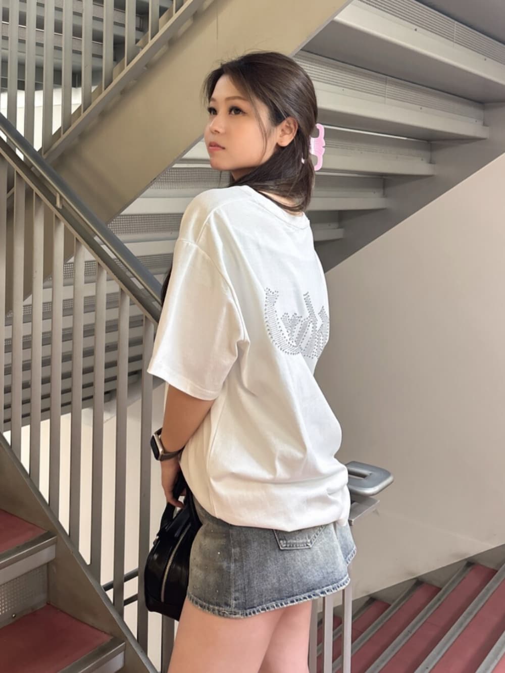 ピンク系のTシャツ/カットソー、ホワイト系のサンダル、ブラック系のハンドバッグを着用したレディースの夏コーディネートの5枚目の写真