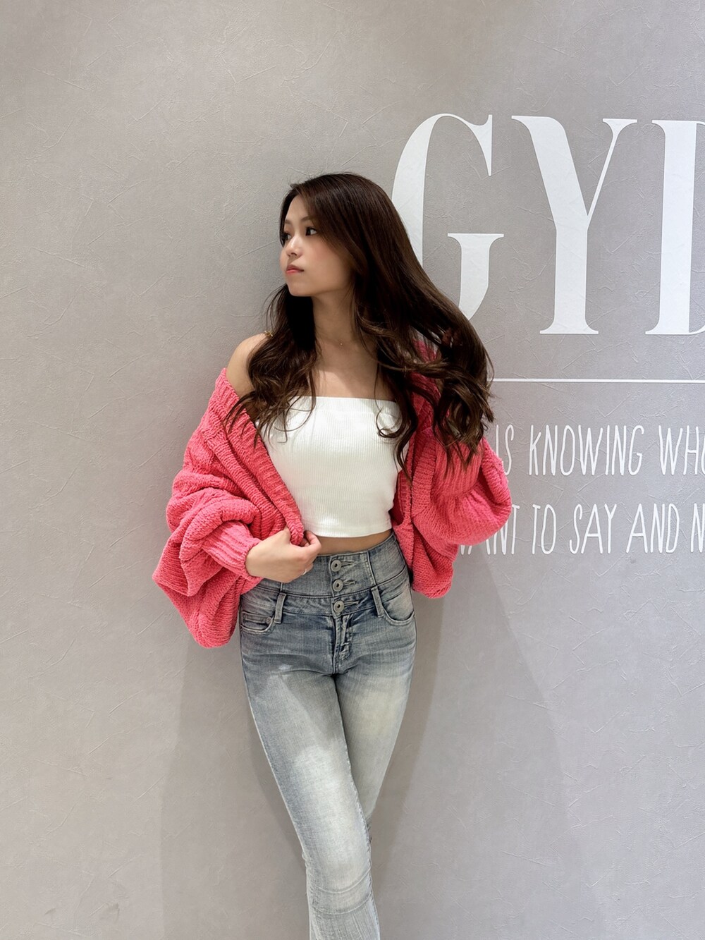 ホワイト系のキャミソール、ピンク系のカーディガン/ボレロ、ブルー系のデニムパンツを着用したレディースの春コーディネートの6枚目の写真