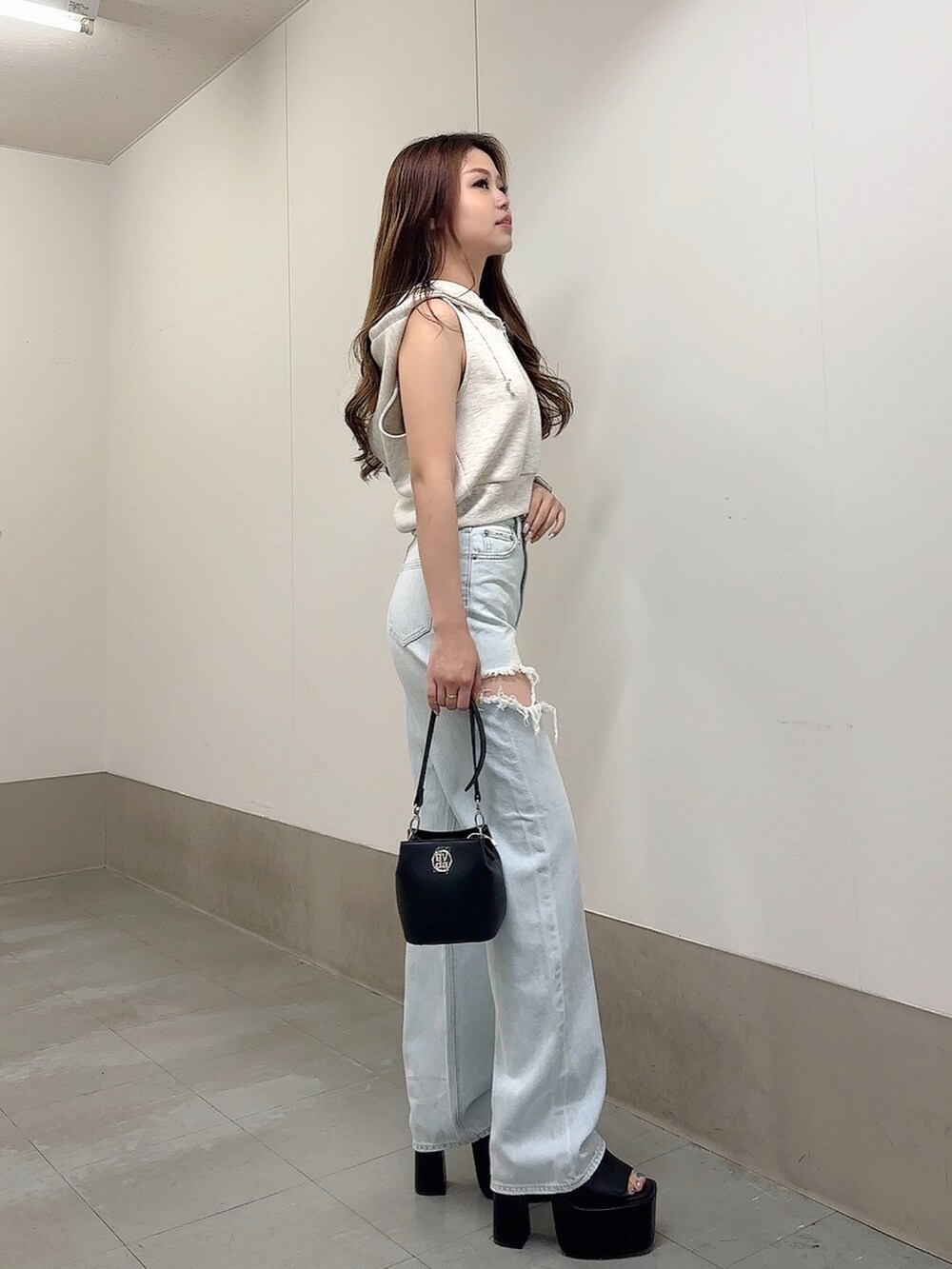 グレー系のTシャツ/カットソー、ブルー系のデニムパンツ、ブラック系のショルダーバッグを着用したレディースの夏コーディネートの3枚目の写真