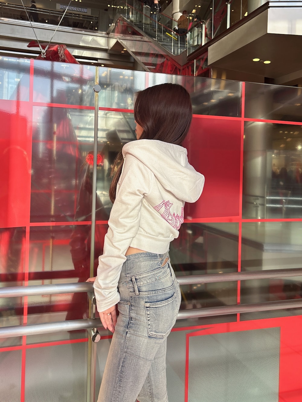 ホワイト系のパーカー、ブルー系のデニムパンツ、ブラック系のブーツを着用したレディースの冬コーディネートの5枚目の写真