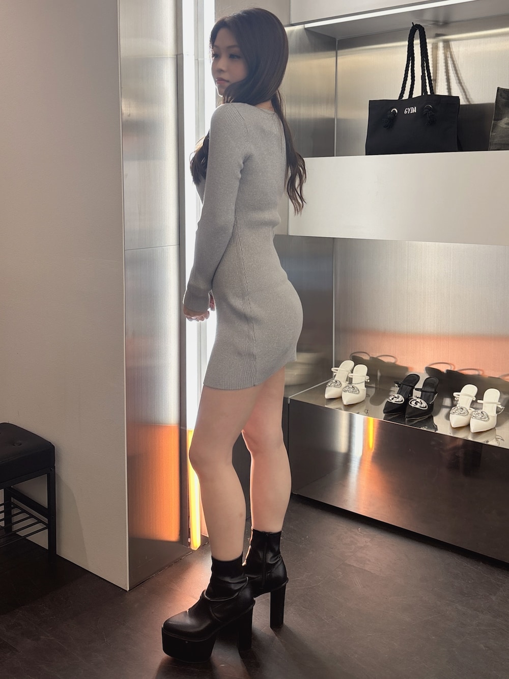 シルバー系のワンピース、ブラック系のブーツを着用したレディースの春コーディネートの2枚目の写真