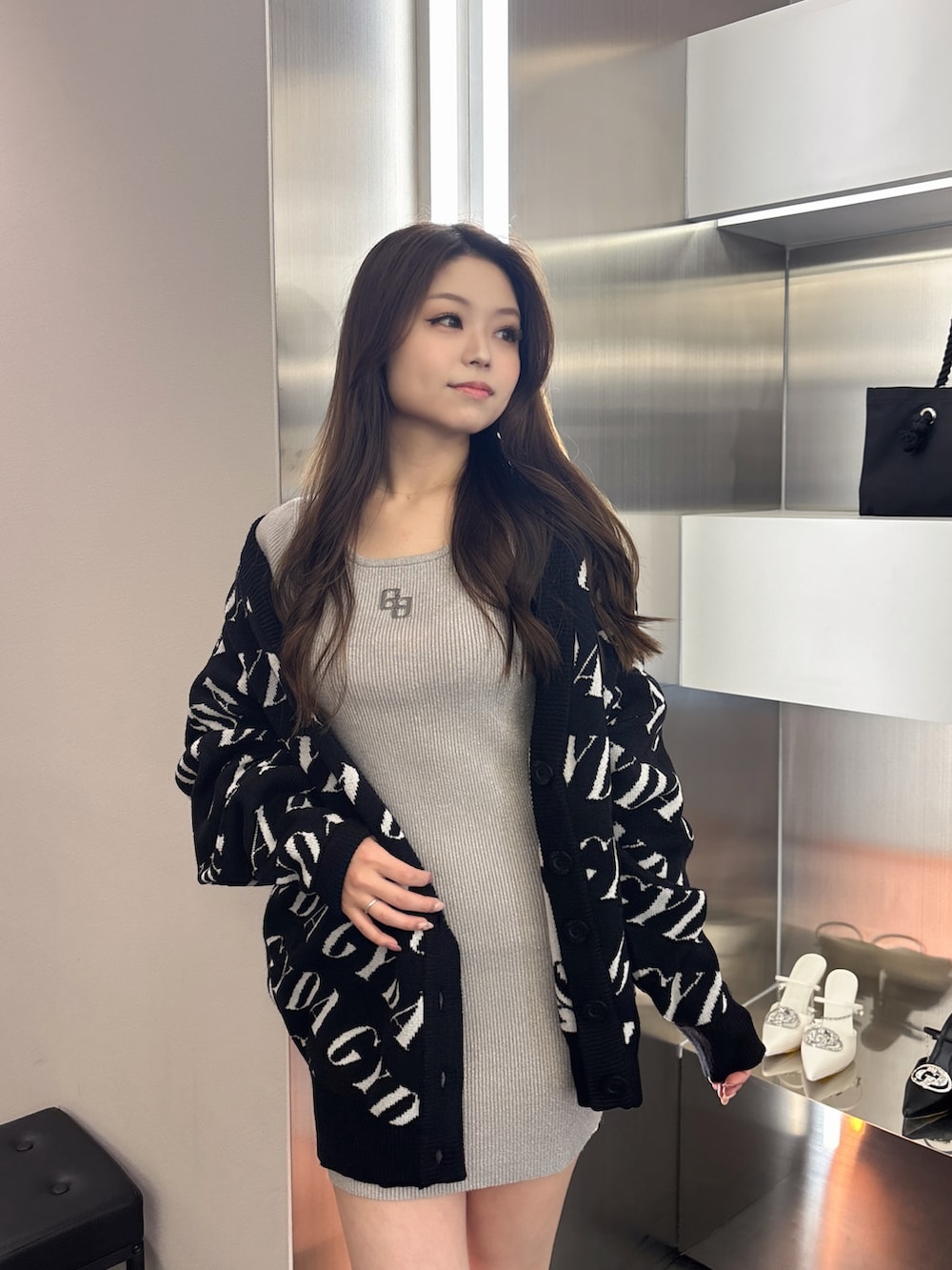 ブラック系のカーディガン/ボレロ、シルバー系のワンピース、ブラック系のブーツを着用したレディースの春コーディネートの4枚目の写真