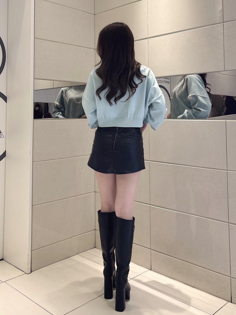 ブルー系のニット/セーター、ブラック系のスカート、ブラック系のブーツを着用したレディースの冬コーディネートの3枚目の写真