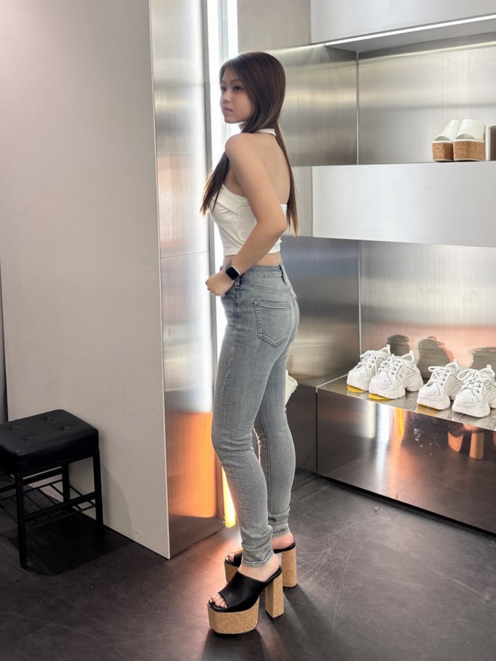 ホワイト系のサンダル、ホワイト系のハンドバッグ、ブルー系のデニムパンツを着用したレディースの夏コーディネートの2枚目の写真