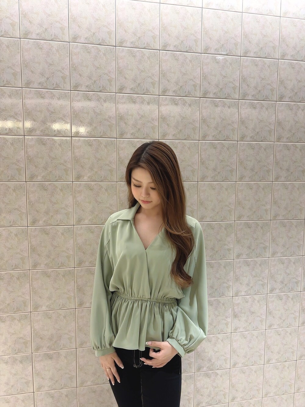 グリーン系のシャツ/ブラウス、ブラック系のデニムパンツ、ホワイト系のパンプスを着用したレディースの冬コーディネートの7枚目の写真