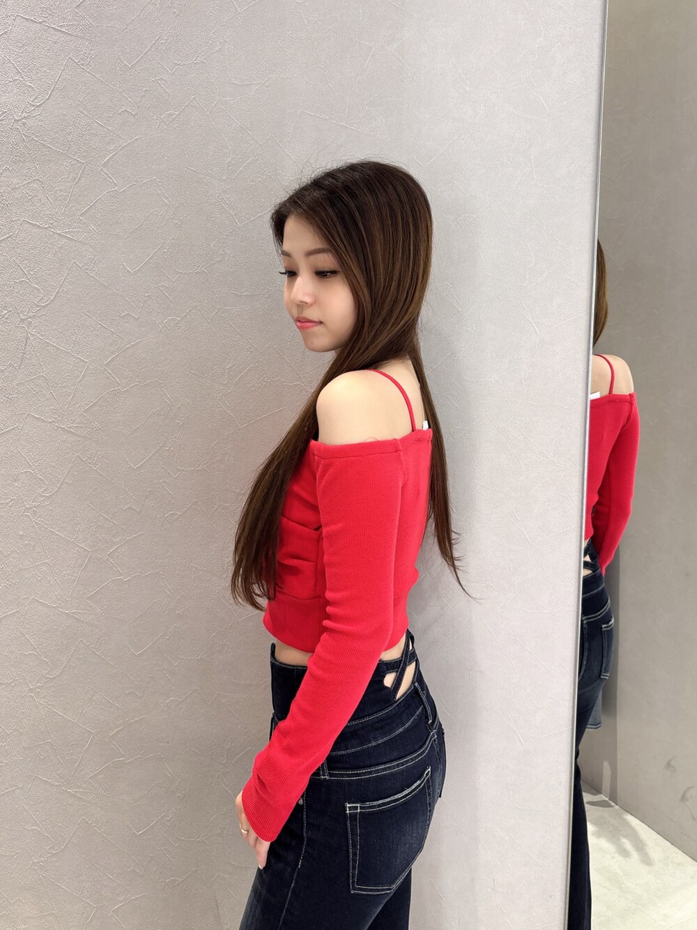 レッド系のTシャツ/カットソー、ブルー系のデニムパンツ、ブラック系のブーツを着用したレディースの秋コーディネートの5枚目の写真