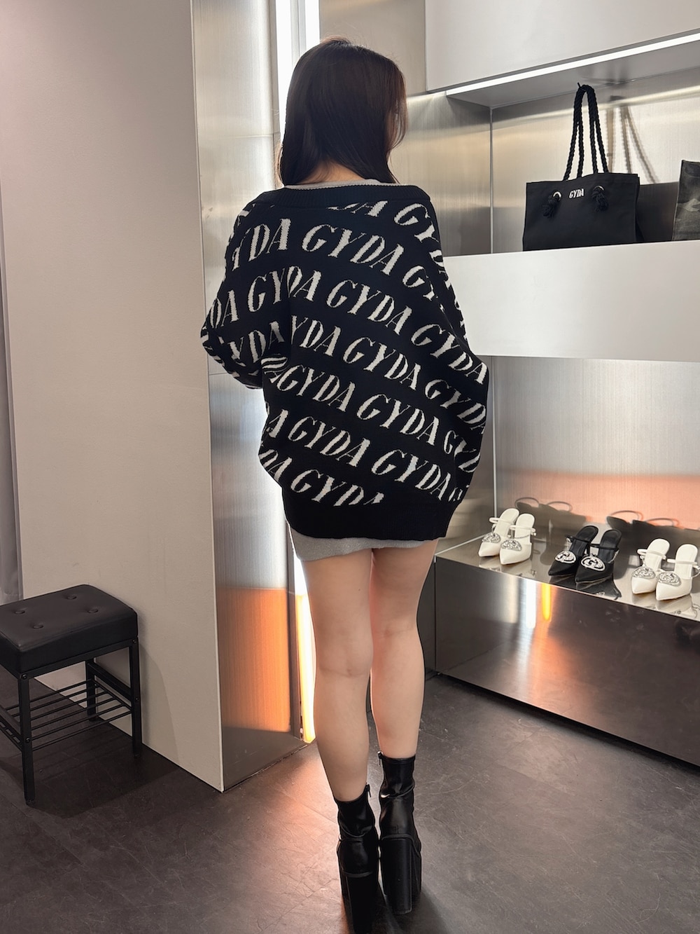 ブラック系のカーディガン/ボレロ、シルバー系のワンピース、ブラック系のブーツを着用したレディースの春コーディネートの3枚目の写真