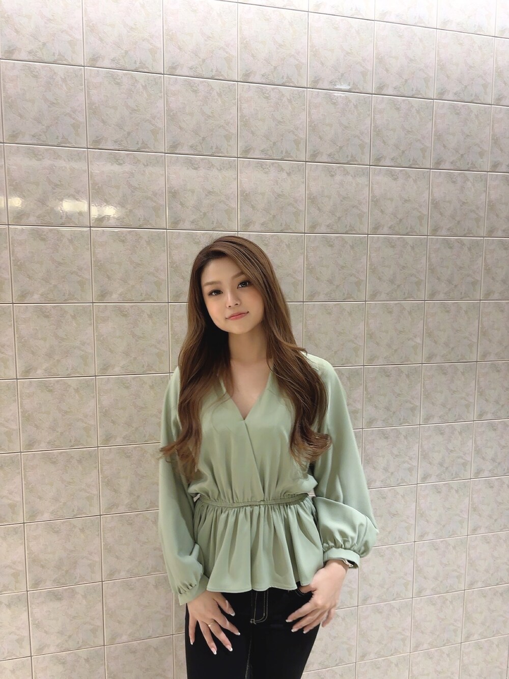 グリーン系のシャツ/ブラウス、ブラック系のデニムパンツ、ホワイト系のパンプスを着用したレディースの冬コーディネートの6枚目の写真