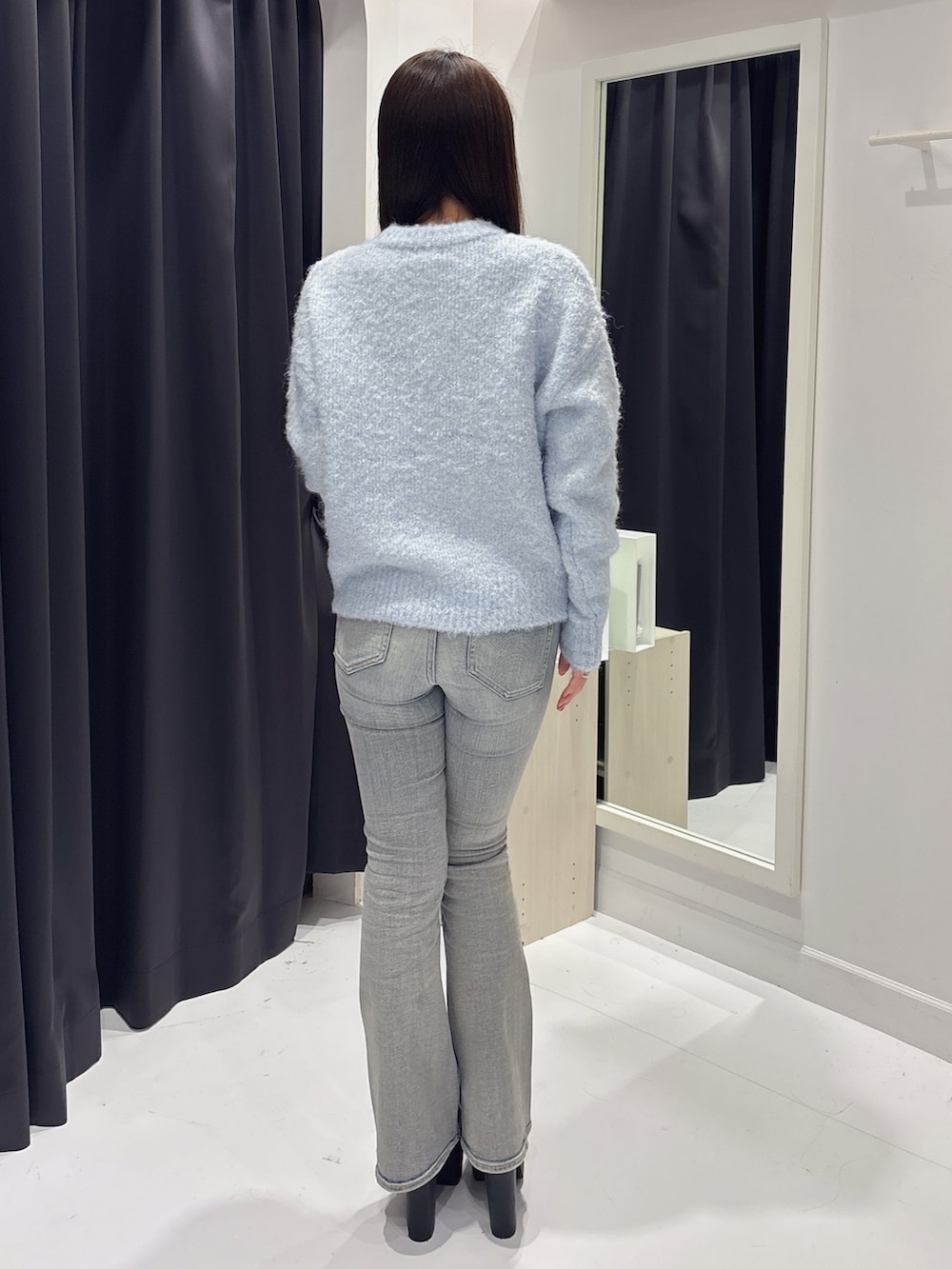 ブルー系のニット/セーター、ブルー系のデニムパンツ、ブラック系のブーツを着用したレディースの冬コーディネートの3枚目の写真