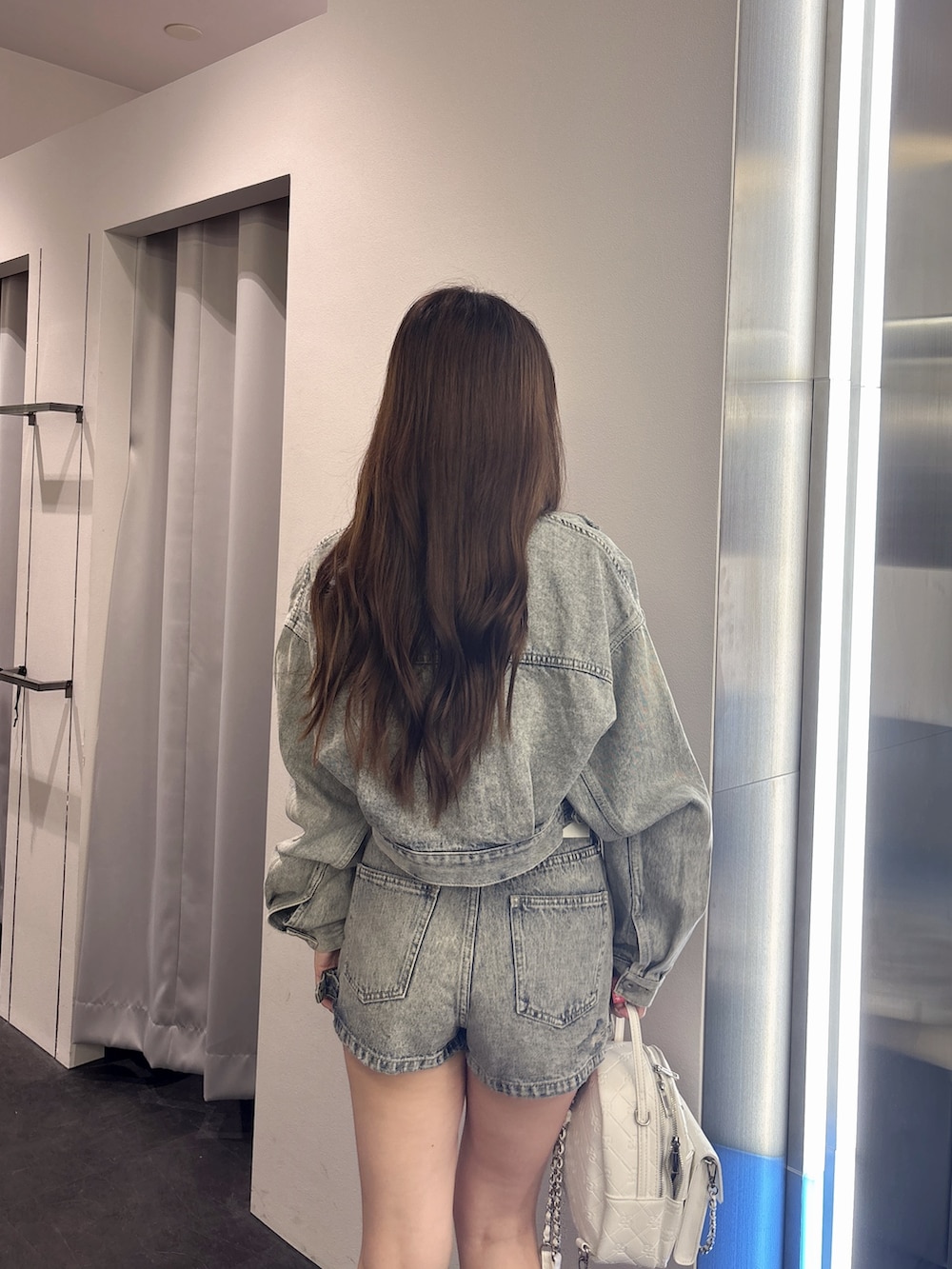 ブルー系のデニムジャケット、ブルー系のデニムパンツ、ホワイト系のバックパック/リュックを着用したレディースの夏コーディネートの6枚目の写真