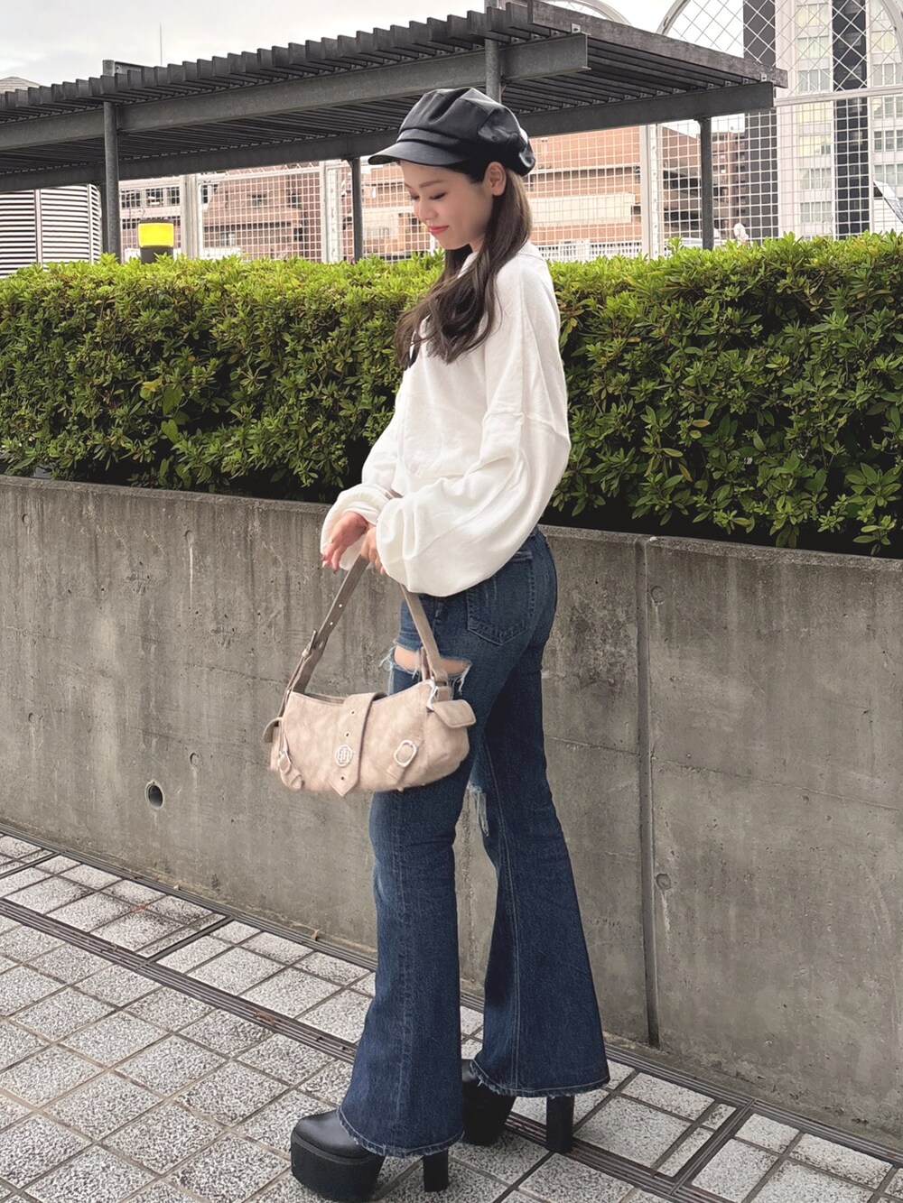 ホワイト系のニット/セーター、ブルー系のデニムパンツ、ベージュ系のショルダーバッグを着用したレディースの秋コーディネートの4枚目の写真