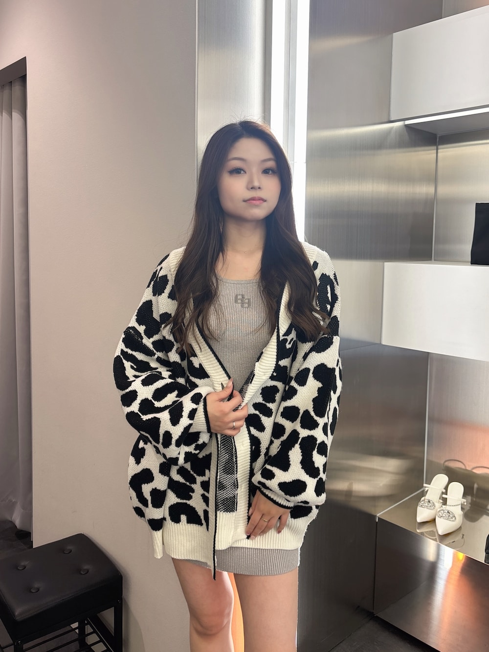 ブラック系のブーツ、ホワイト系のカーディガン/ボレロ、シルバー系のワンピースを着用したレディースの春コーディネートの4枚目の写真