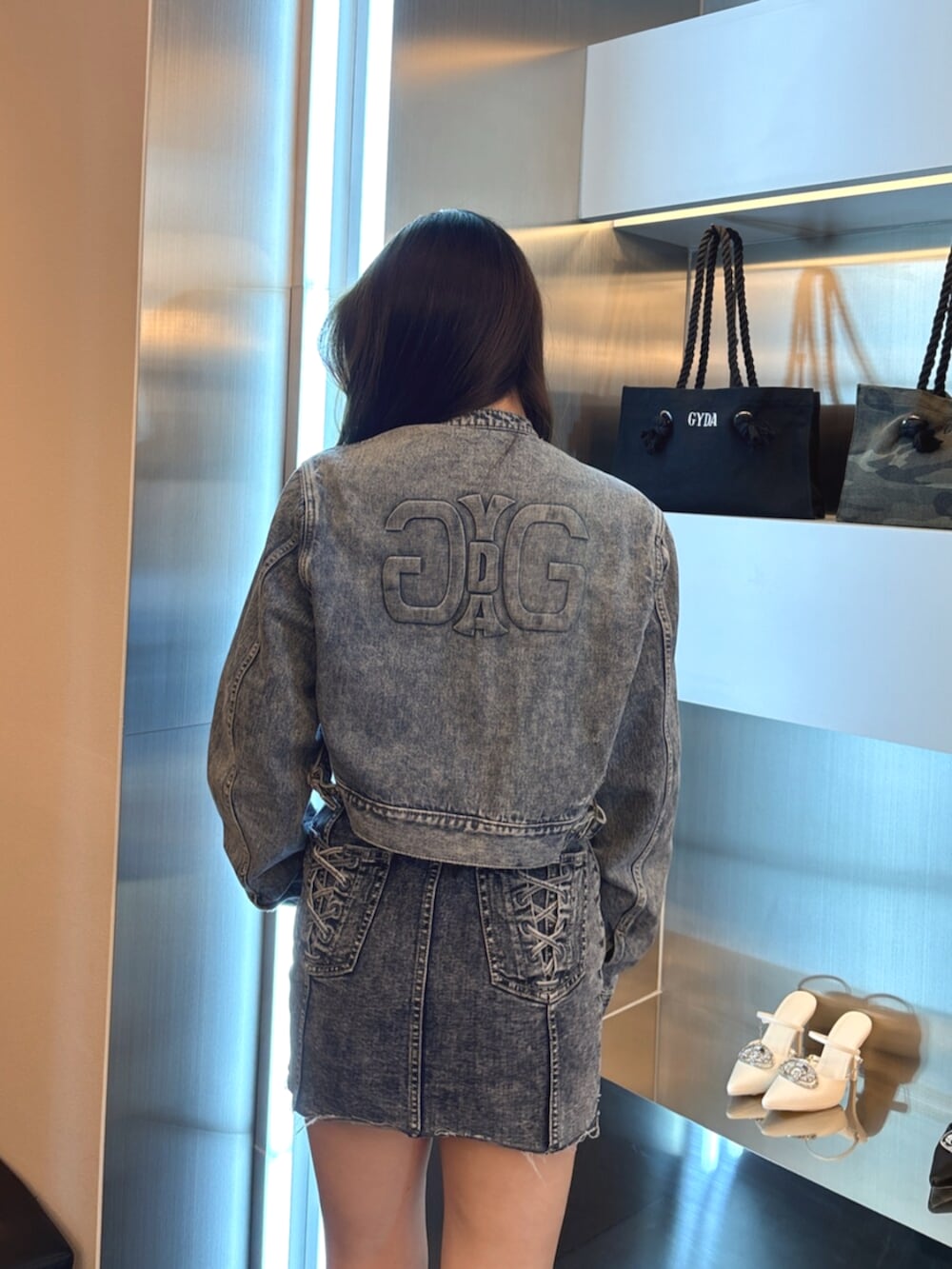 ブラック系のブーツ、ブルー系のワンピース、ブルー系のデニムジャケットを着用したレディースの春コーディネートの6枚目の写真