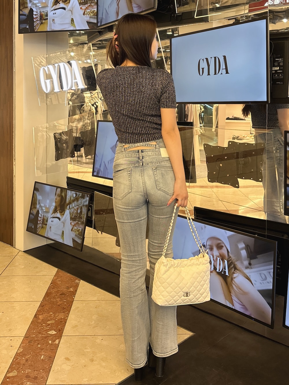 ブラック系のニット/セーター、ブルー系のデニムパンツ、ブラック系のブーツを着用したレディースの春コーディネートの3枚目の写真