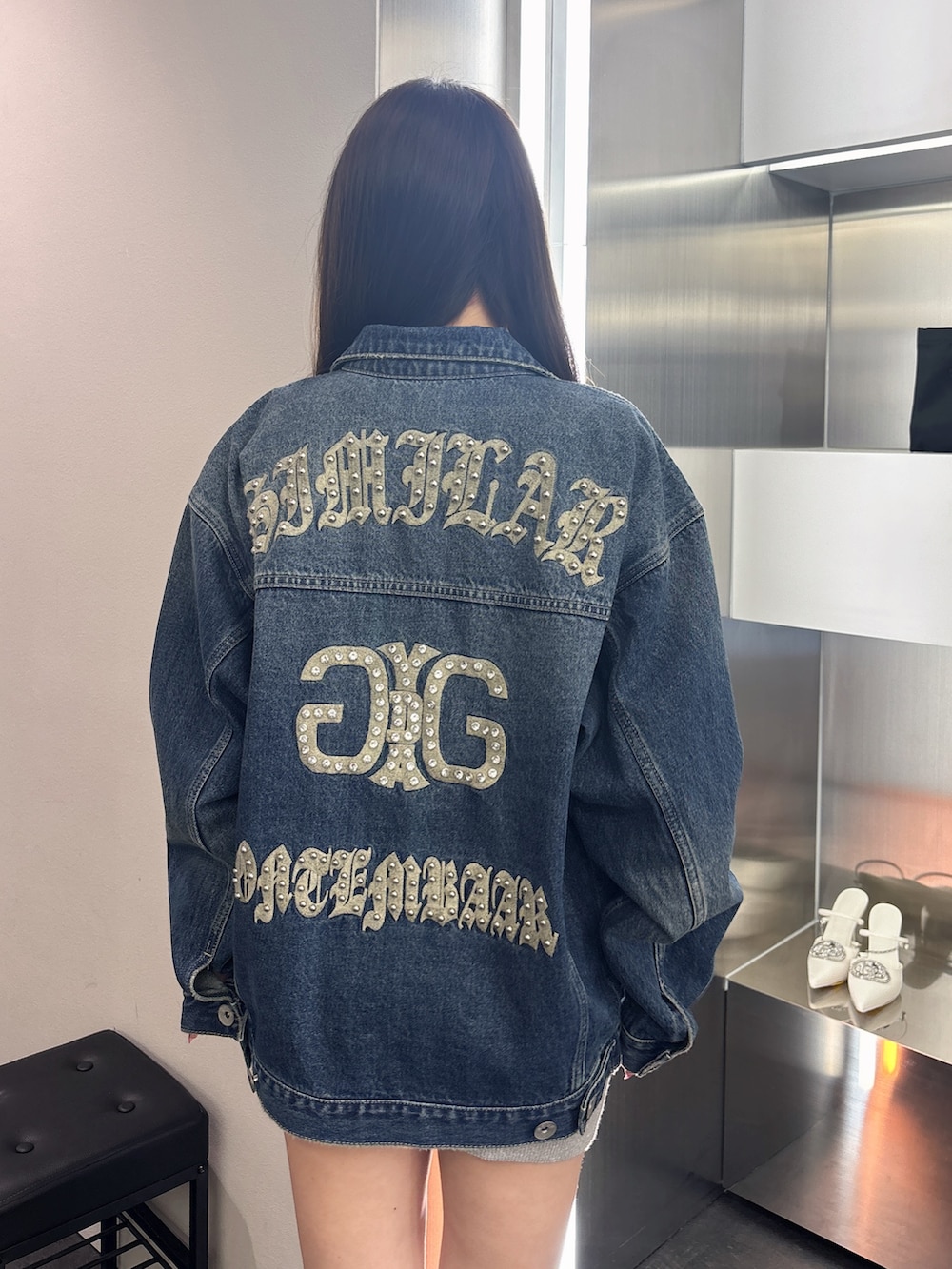 ブラック系のブーツ、シルバー系のワンピース、ブルー系のデニムジャケットを着用したレディースの春コーディネートの6枚目の写真