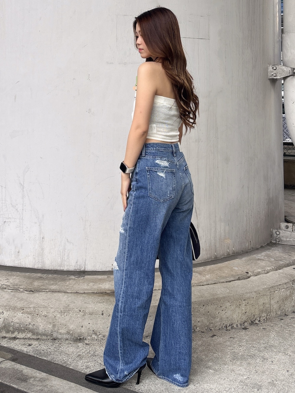 ホワイト系のニット/セーター、ブルー系のデニムパンツ、ホワイト系のパンプスを着用したレディースの夏コーディネートの2枚目の写真