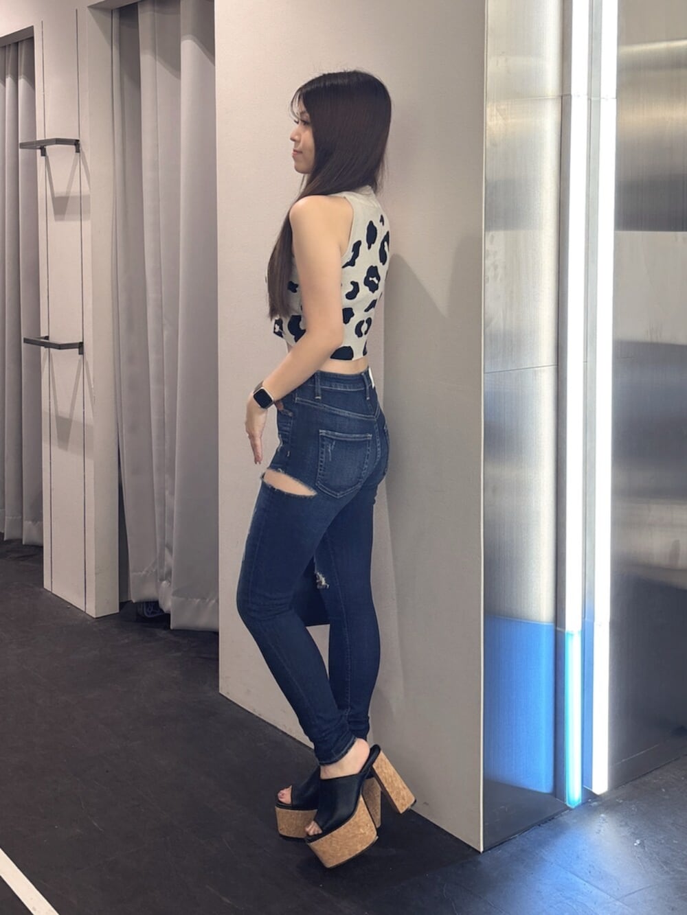 ブルー系のデニムパンツ、ホワイト系のサンダル、ピンク系のボストンバッグを着用したレディースの夏コーディネートの2枚目の写真