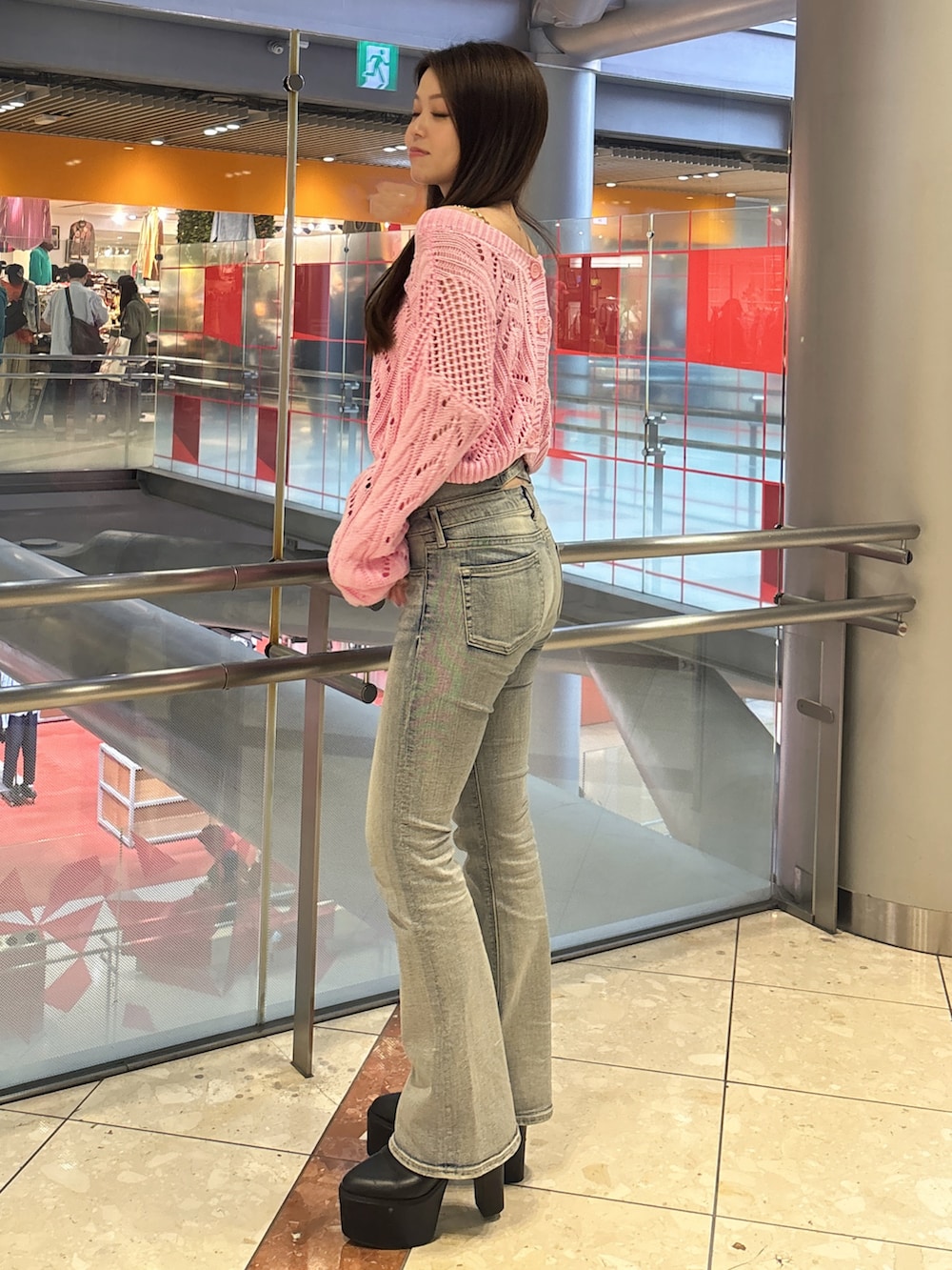 ピンク系のニット/セーター、ホワイト系のキャミソール、ブルー系のデニムパンツを着用したレディースの春コーディネートの2枚目の写真