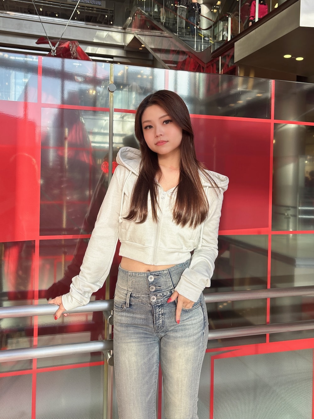 ホワイト系のパーカー、ブルー系のデニムパンツ、ブラック系のブーツを着用したレディースの冬コーディネートの4枚目の写真