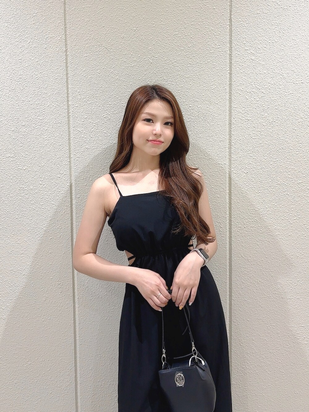 ブラック系のワンピース、ブラック系のショルダーバッグ、ホワイト系のサンダルを着用したレディースの夏コーディネートの5枚目の写真