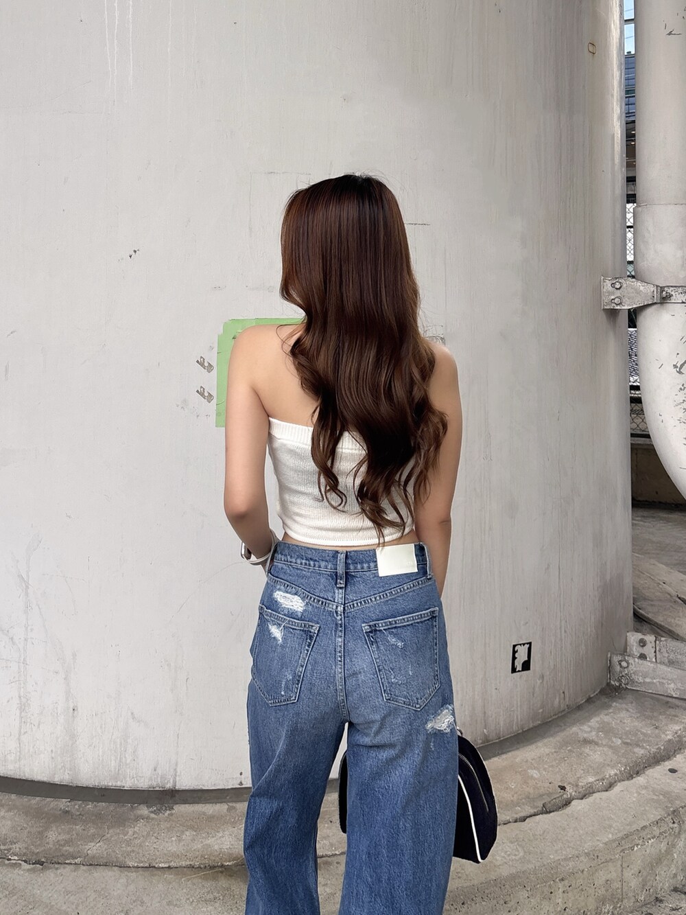 ホワイト系のニット/セーター、ブルー系のデニムパンツ、ホワイト系のパンプスを着用したレディースの夏コーディネートの6枚目の写真