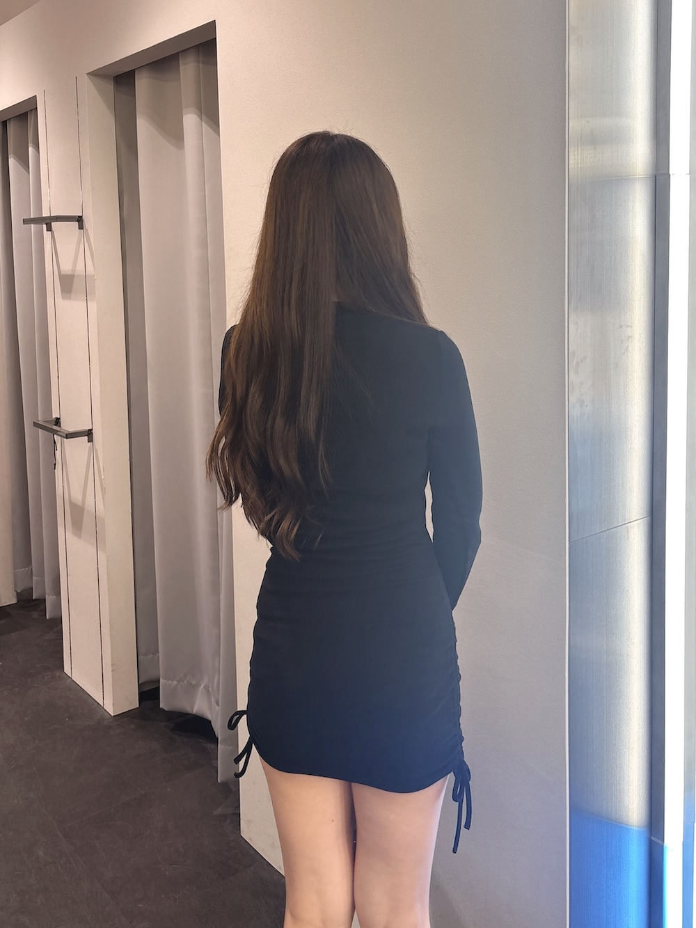 ブラック系のワンピース、ブラック系のブーツを着用したレディースの秋コーディネートの6枚目の写真