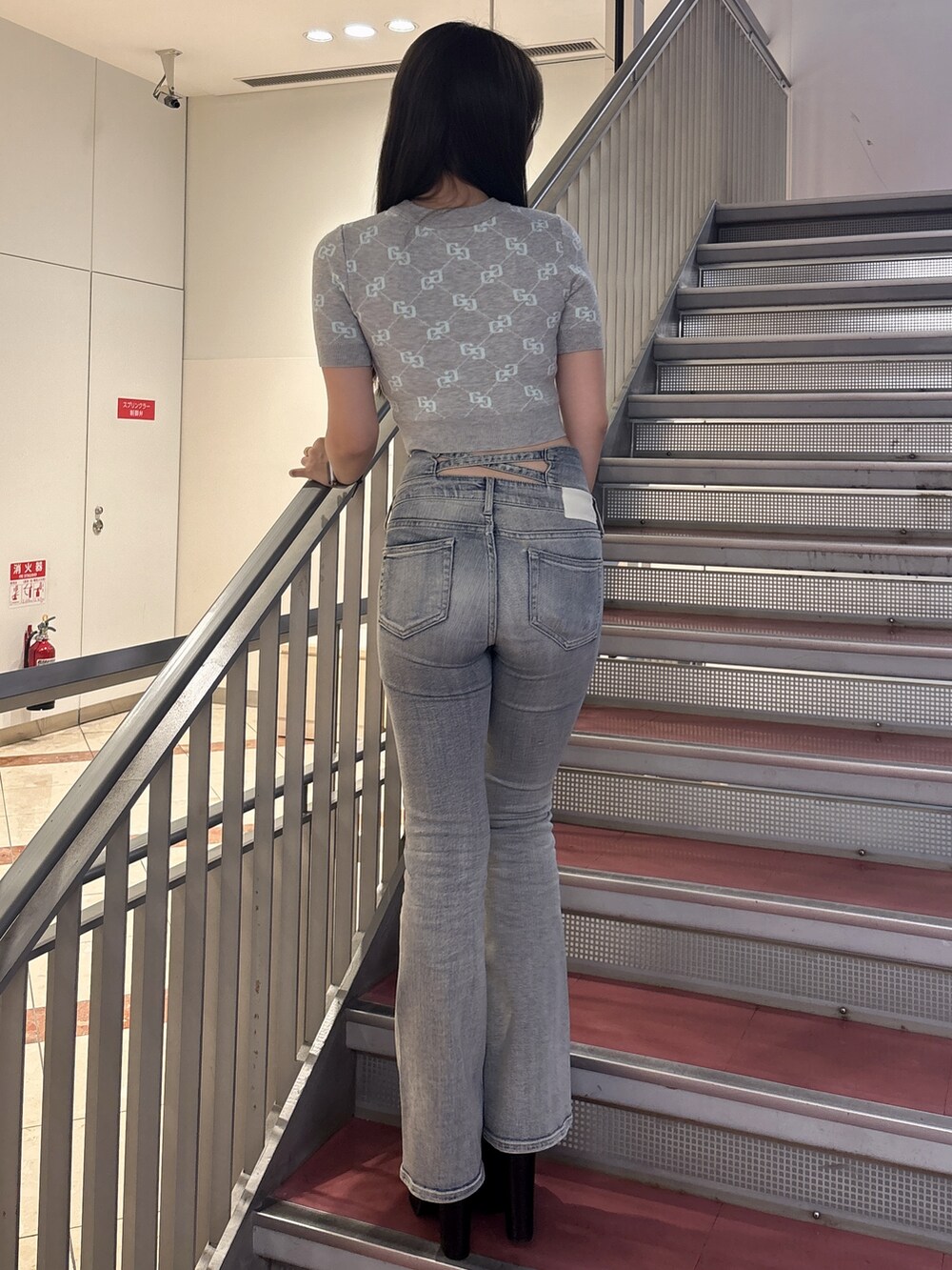グレー系のニット/セーター、ブルー系のデニムパンツ、ブラック系のサンダルを着用したレディースの春コーディネートの3枚目の写真